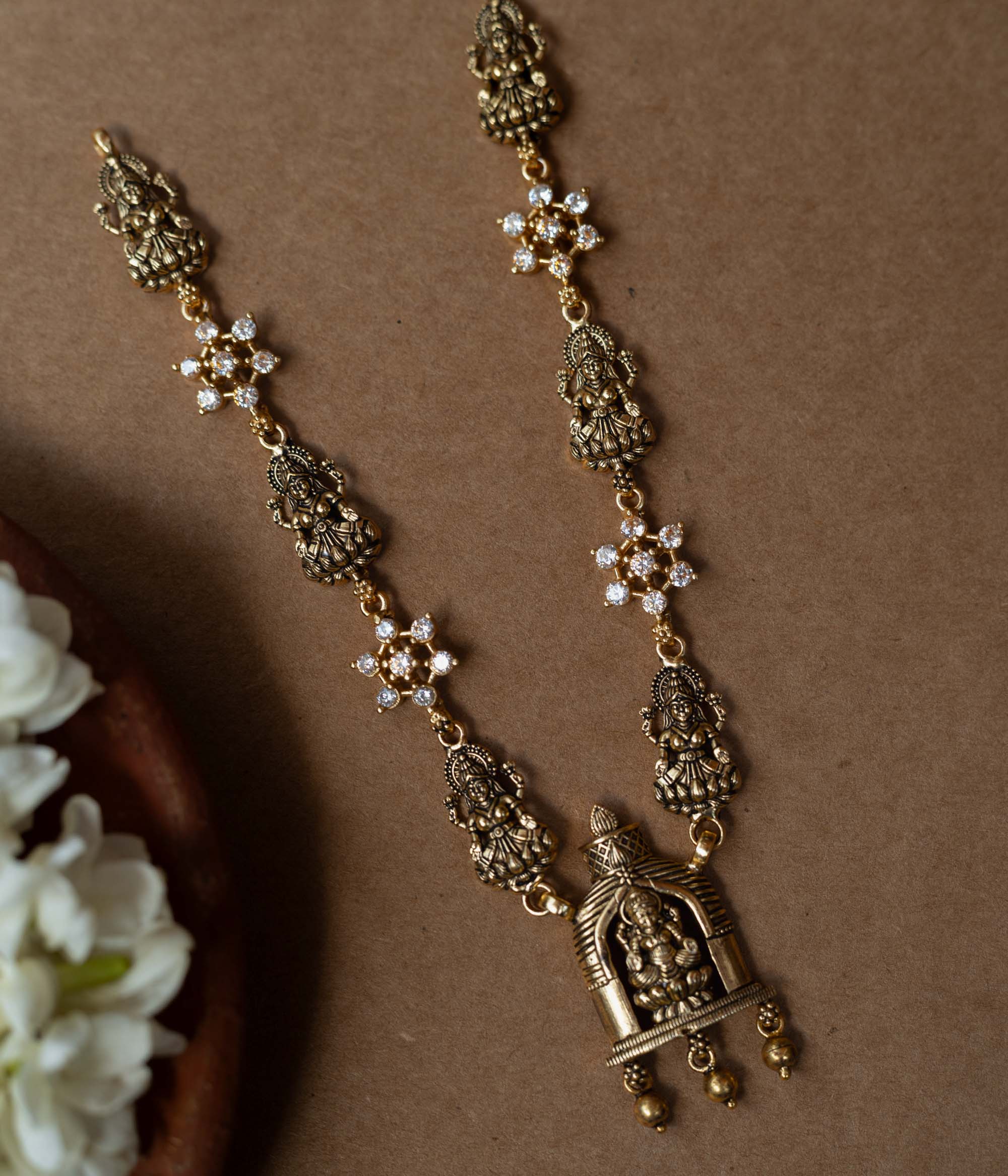 A 92.5 sterling silver Gauri Temple Pendant Necklace, featuring antique-finish Lakshmi motifs, floral crystal links, and a central temple pendant, invoking divine elegance for festive and traditional celebrations.