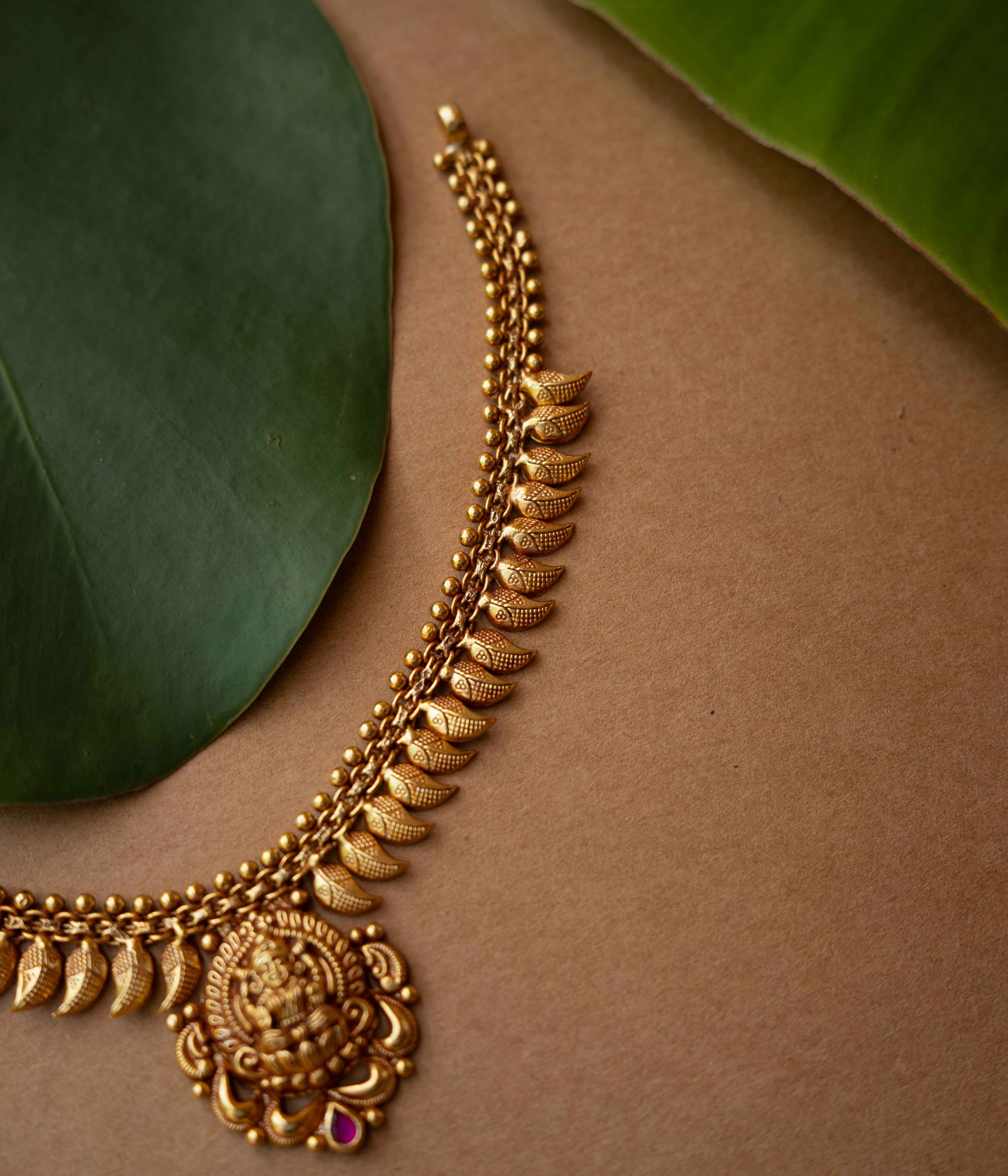Antique gold necklace with Goddess Lakshmi pendant and crescent motifs from Temple Collection.