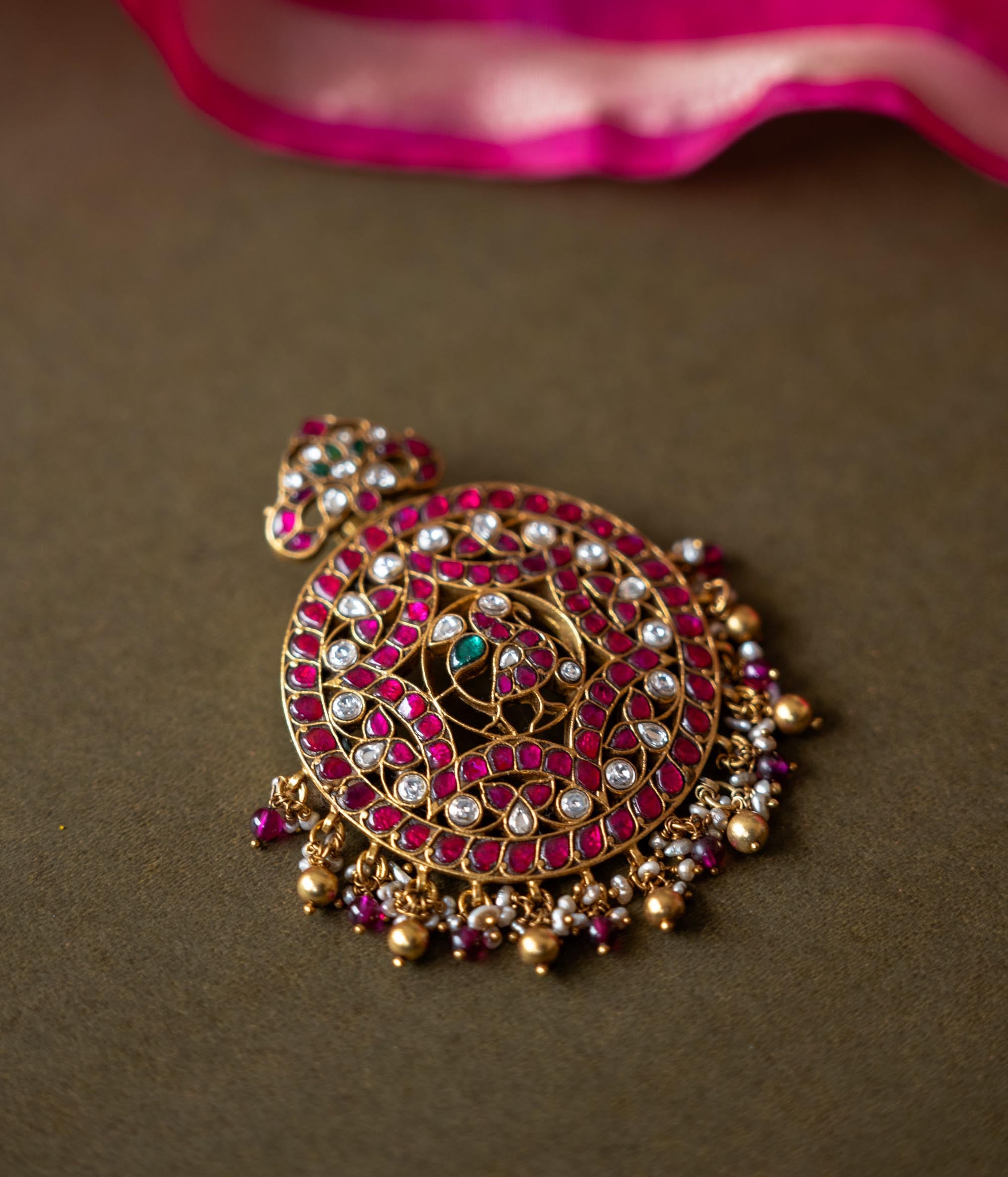 A 92.5 sterling silver piece featuring red and white Kundan stones and pearls, described as a timeless masterpiece adorned with radiant gemstones and intricate gold craftsmanship, echoing the grandeur of heritage and tradition.