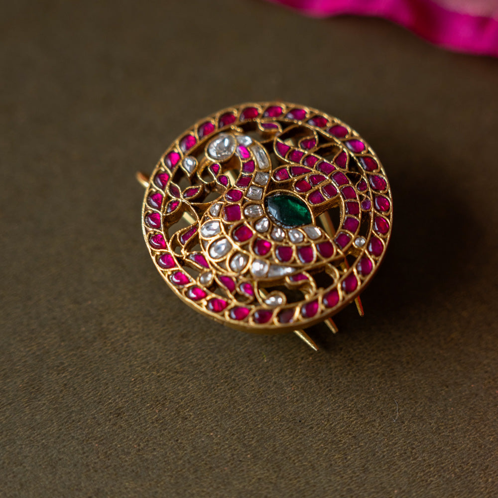 A handcrafted 92.5 sterling silver piece, plated with 22ct gold, featuring red, green, and white Kundan stones, embodying an exquisite fusion of tradition and elegance with intricate Kundan work and radiant gemstones.