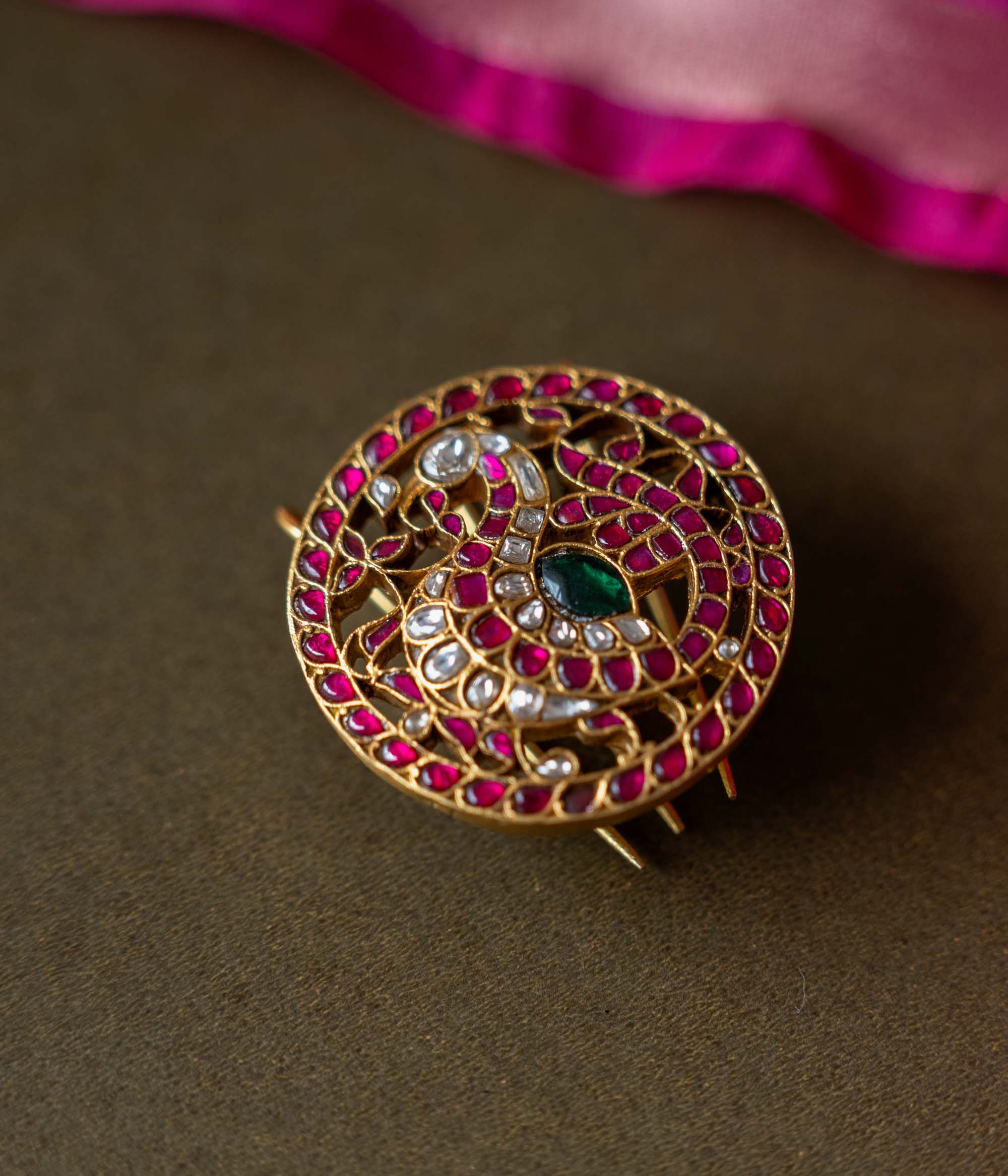 A handcrafted 92.5 sterling silver piece, plated with 22ct gold, featuring red, green, and white Kundan stones, embodying an exquisite fusion of tradition and elegance with intricate Kundan work and radiant gemstones.