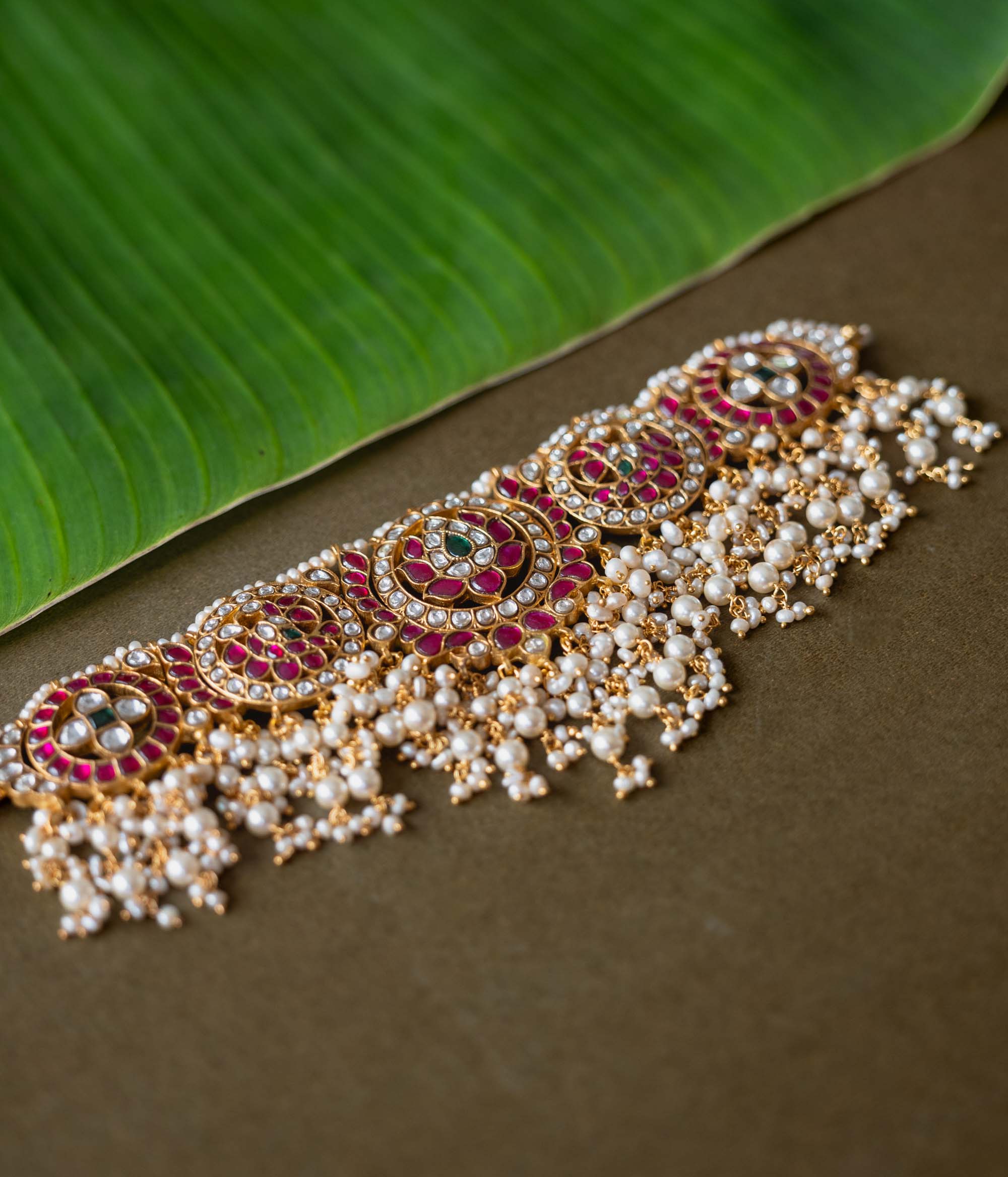 A handcrafted 92.5 sterling silver choker, featuring white, red, and green Kundan stones and pearls, showcasing intricate Kundan artistry and evoking the splendor of timeless royal elegance.