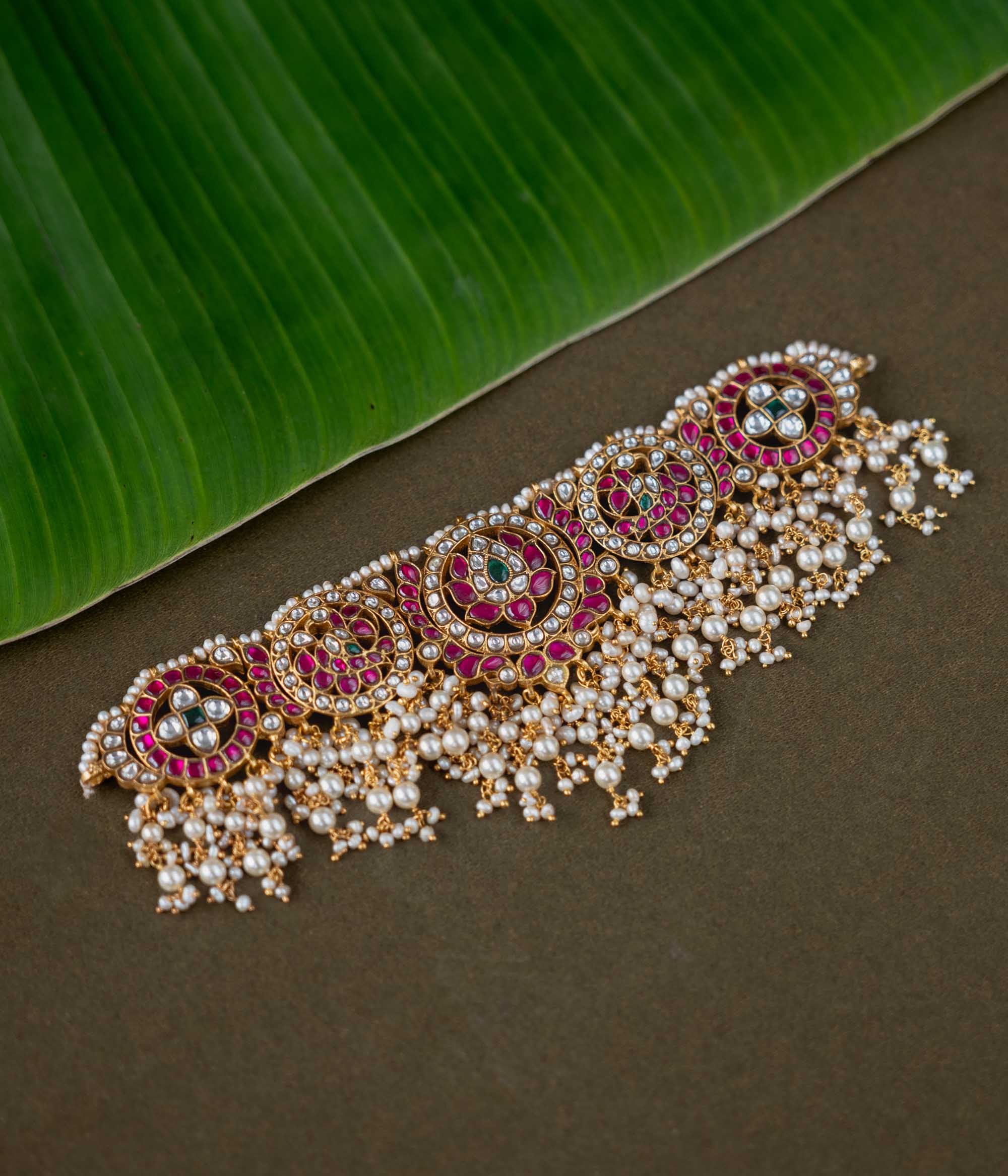 A handcrafted 92.5 sterling silver choker, featuring white, red, and green Kundan stones and pearls, showcasing intricate Kundan artistry and evoking the splendor of timeless royal elegance.