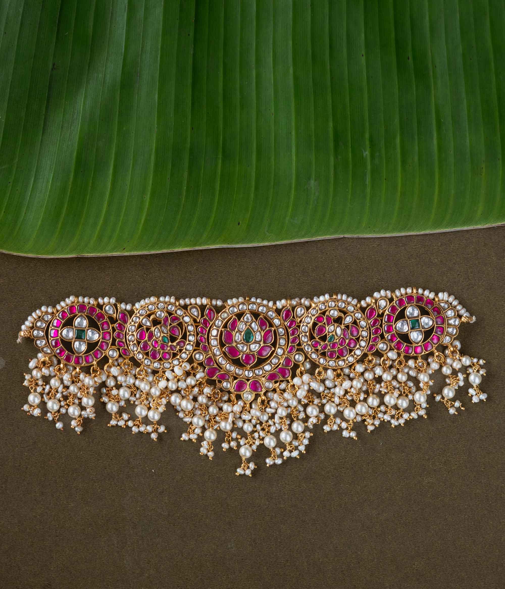 A handcrafted 92.5 sterling silver choker, featuring white, red, and green Kundan stones and pearls, showcasing intricate Kundan artistry and evoking the splendor of timeless royal elegance.