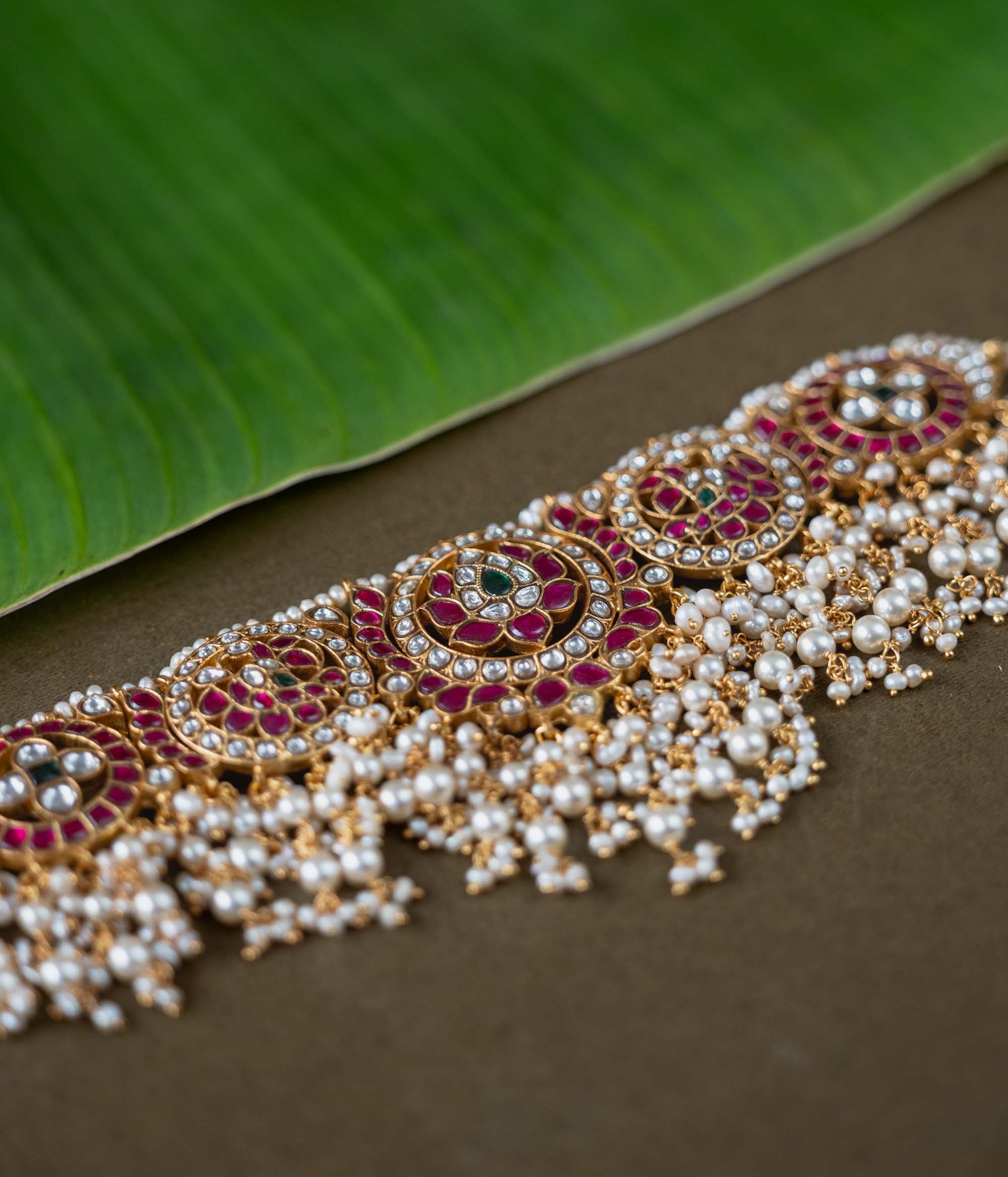 A handcrafted 92.5 sterling silver choker, featuring white, red, and green Kundan stones and pearls, showcasing intricate Kundan artistry and evoking the splendor of timeless royal elegance.