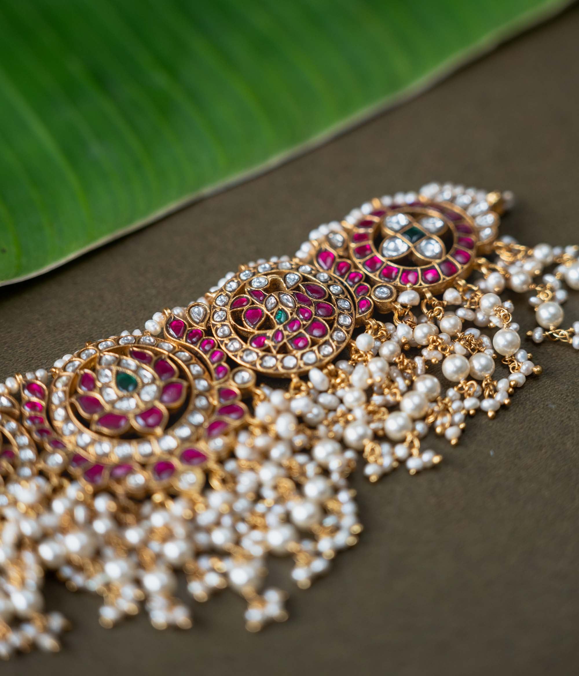 A handcrafted 92.5 sterling silver choker, featuring white, red, and green Kundan stones and pearls, showcasing intricate Kundan artistry and evoking the splendor of timeless royal elegance.