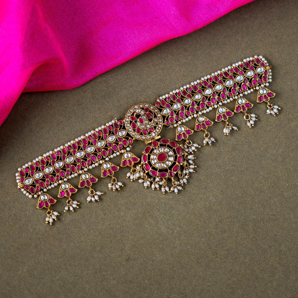 A 92.5 sterling silver choker, adorned with dazzling polki stones, red Kundan stones, and pearl droplets, embodying regal charm and timeless grace.