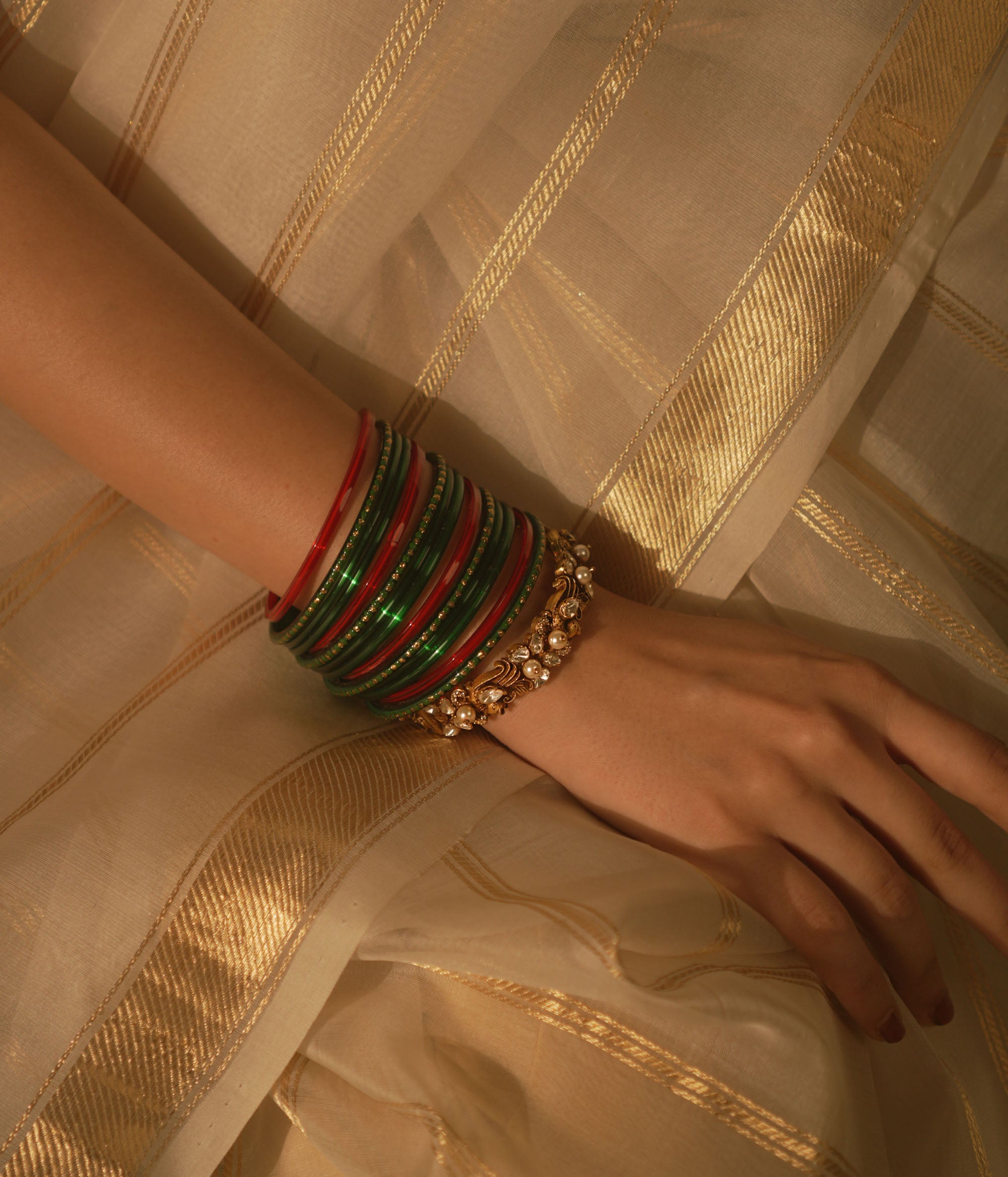 Golden temple bangle with peacock motif, Polki stones, and pearl detailing.