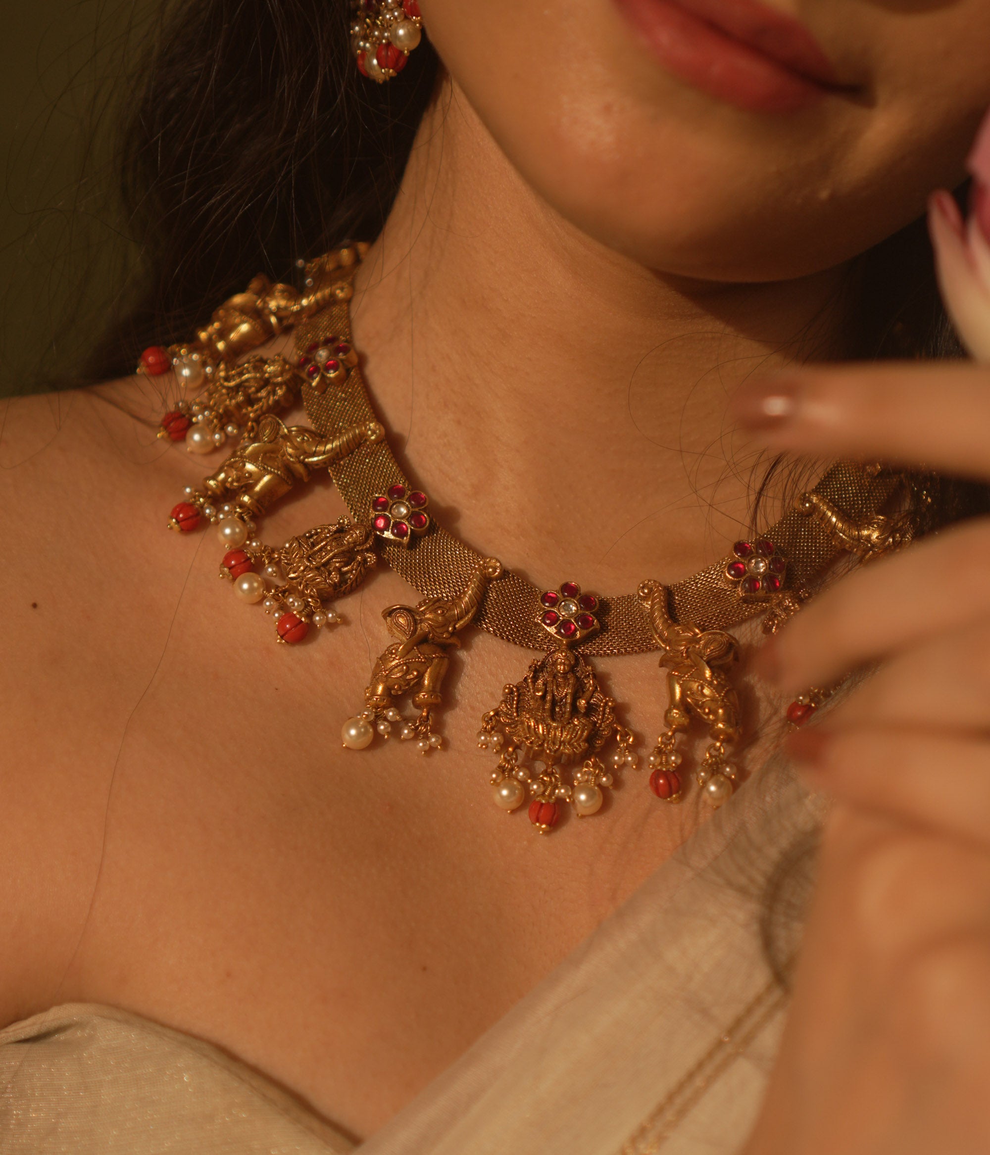 Temple collection Aamal Necklace featuring Goddess Lakshmi, elephant motifs, pink Kundan stones, pearls, and coral beads.