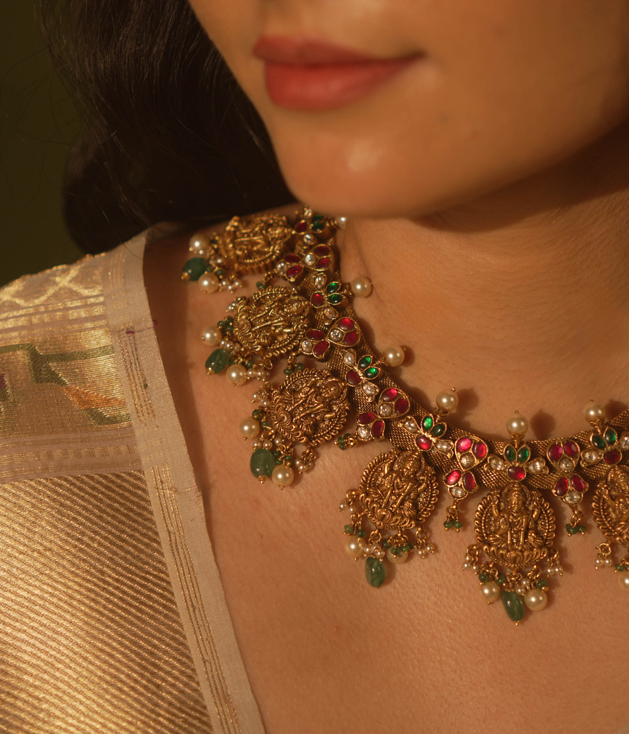 Temple collection Raahi Necklace adorned with seated Lakshmi motifs, pink and green Kundan stones, and Basra pearls.