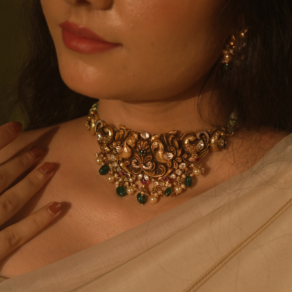 Temple collection choker with intricate peacock and floral carvings, adorned in Polki stones and pearls for ethnic elegance.