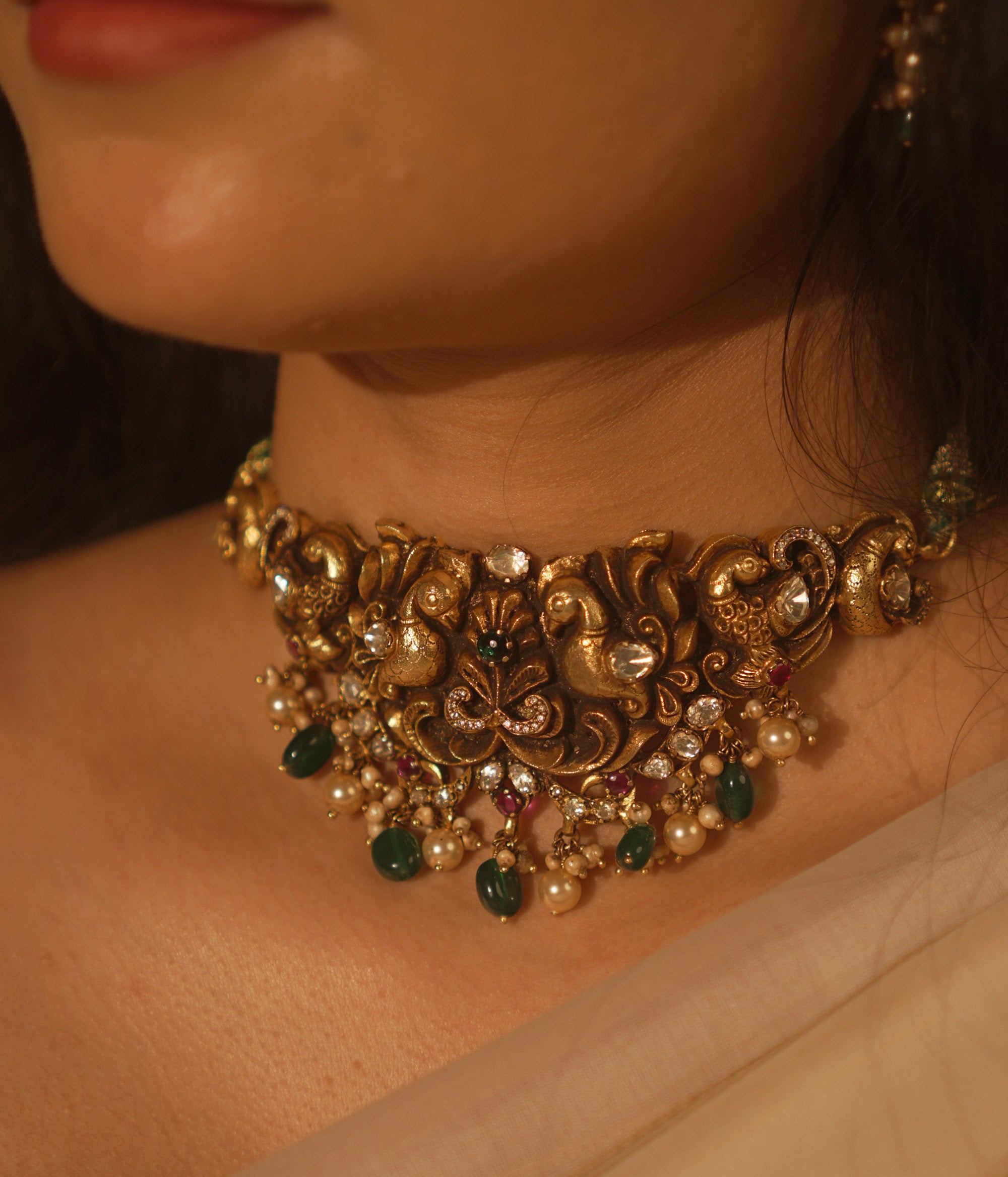 Temple collection choker with intricate peacock and floral carvings, adorned in Polki stones and pearls for ethnic elegance.