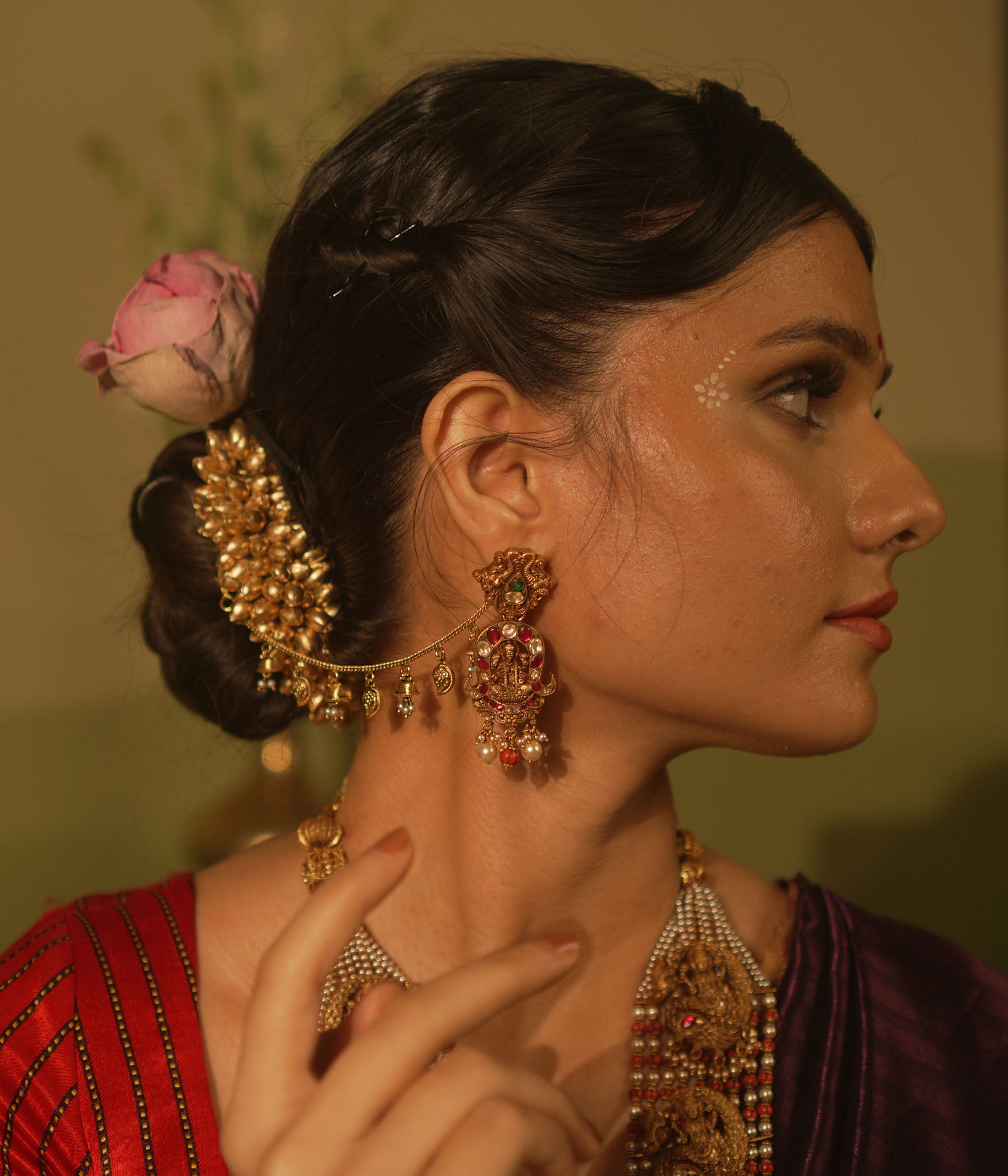 Traditional temple ear chain with Lakshmi motif, red and green Kundan stones, coral beads, and pearl danglers.