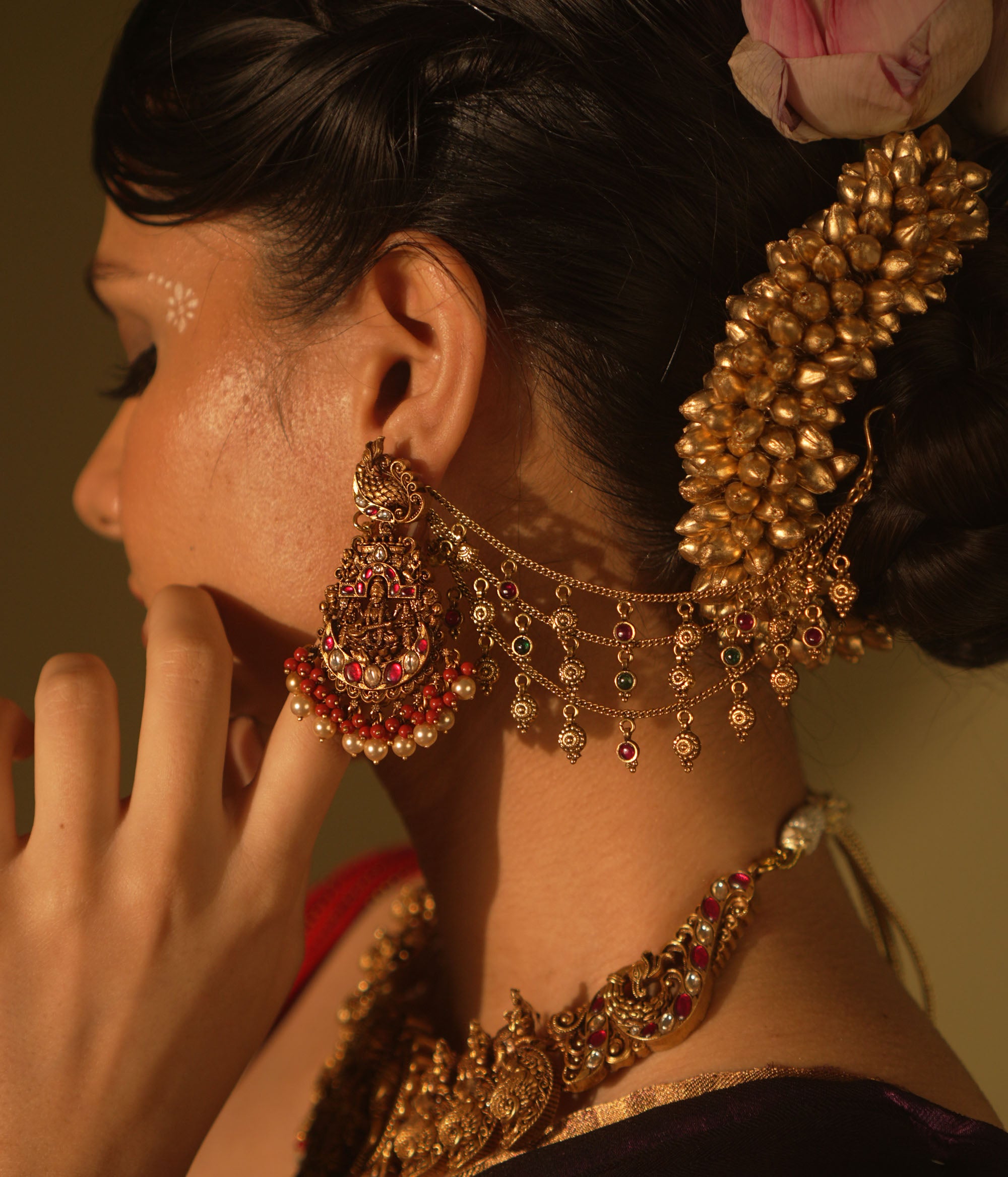 Ranjaki temple earrings with goddess motif, peacock stud, red-green Kundan, pearls, and cascading chains.