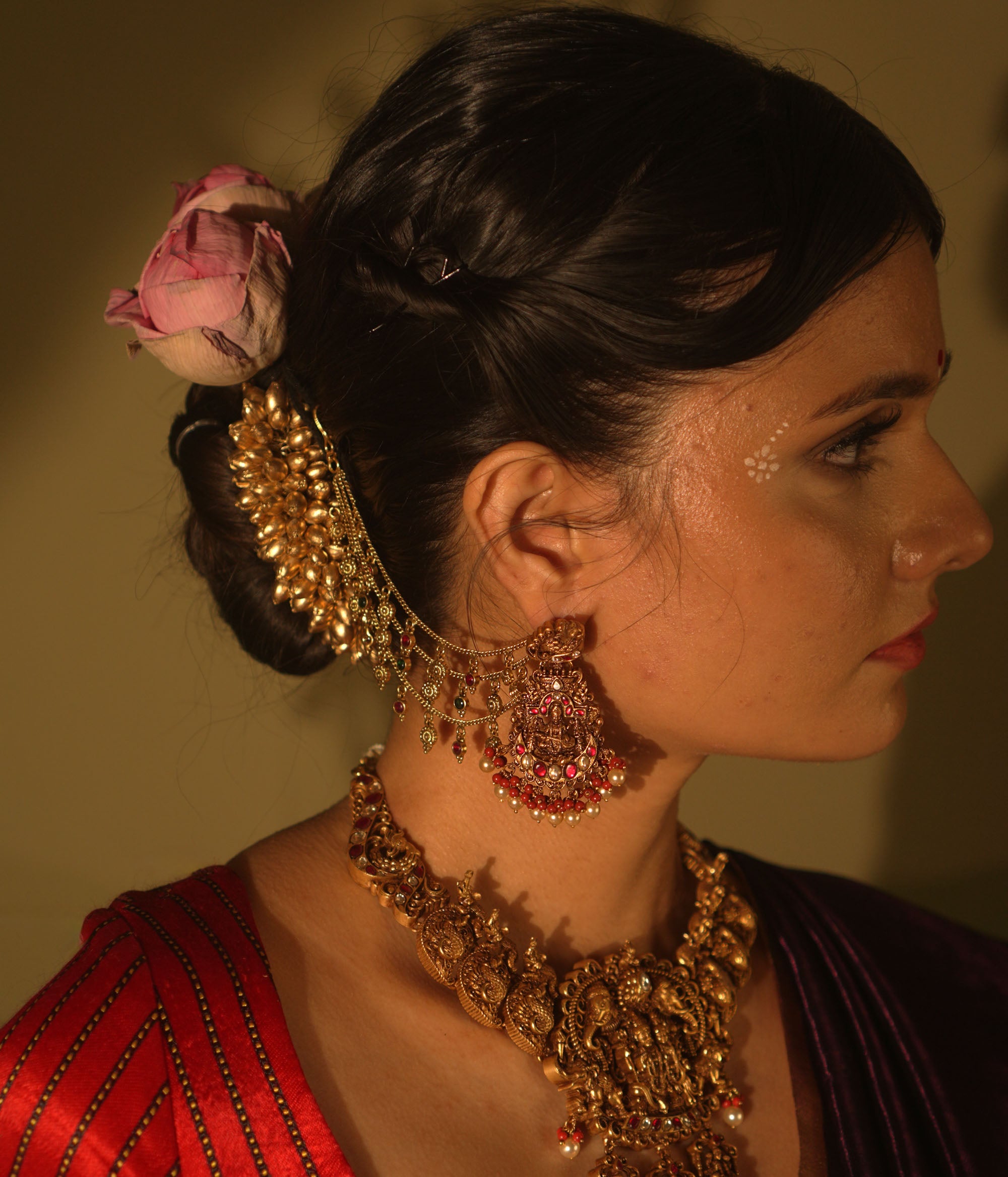 Ranjaki temple earrings with goddess motif, peacock stud, red-green Kundan, pearls, and cascading chains.