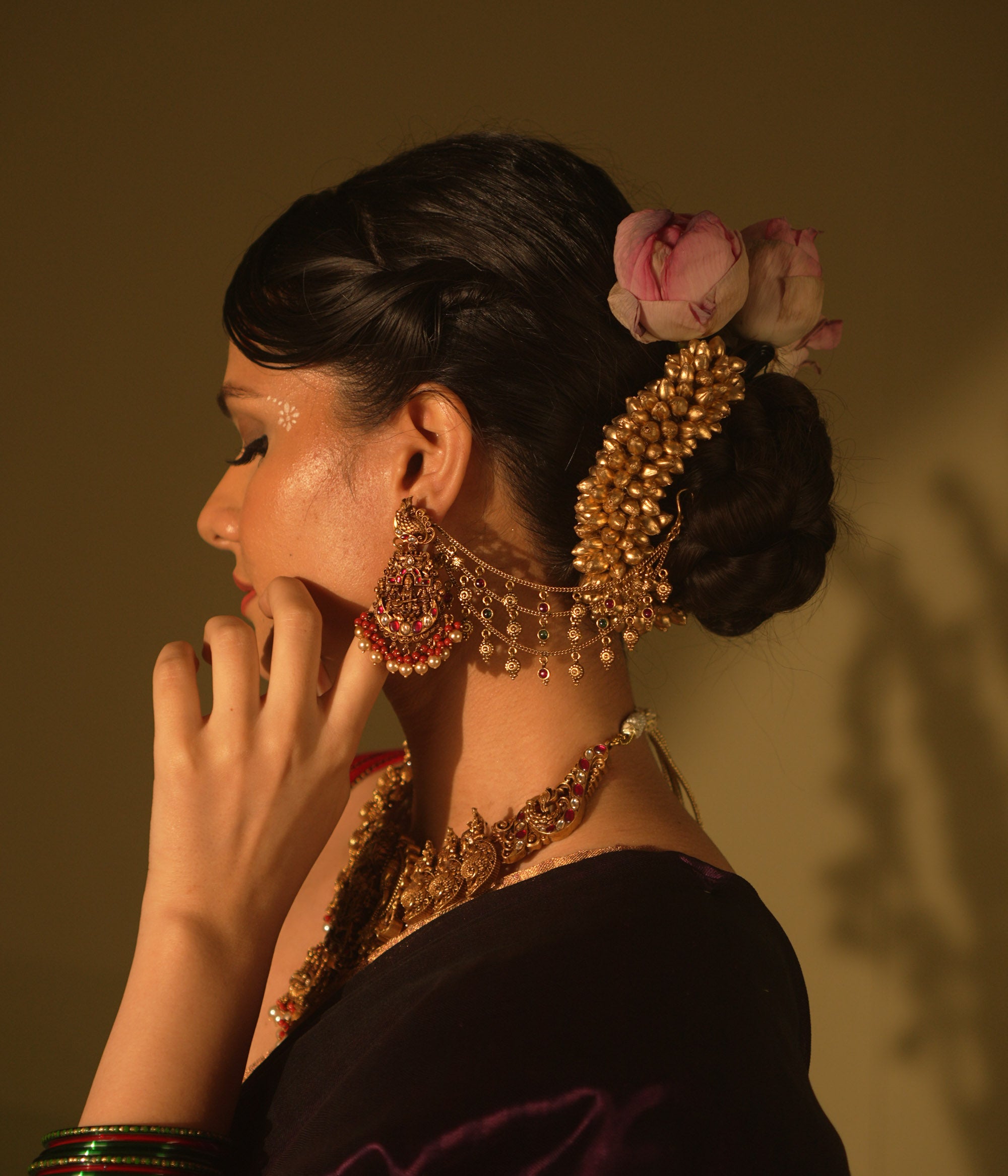 Ranjaki temple earrings with goddess motif, peacock stud, red-green Kundan, pearls, and cascading chains.