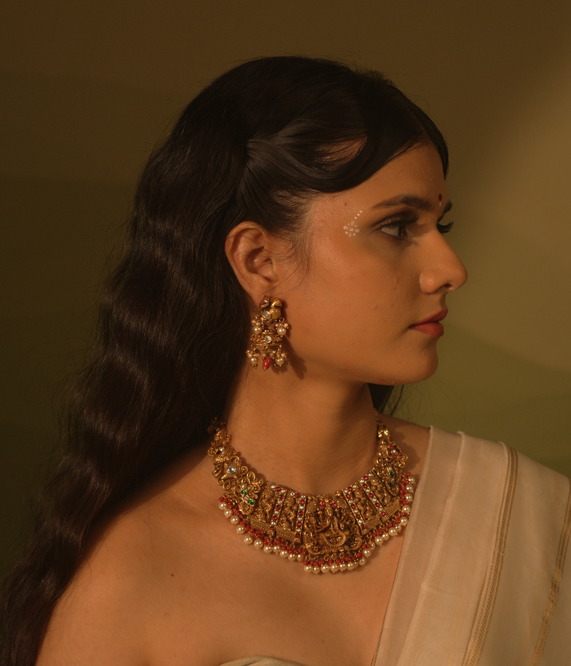Temple jhumkas with peacock motifs, coral details, and Basra pearls—blending tradition with vibrant beauty.