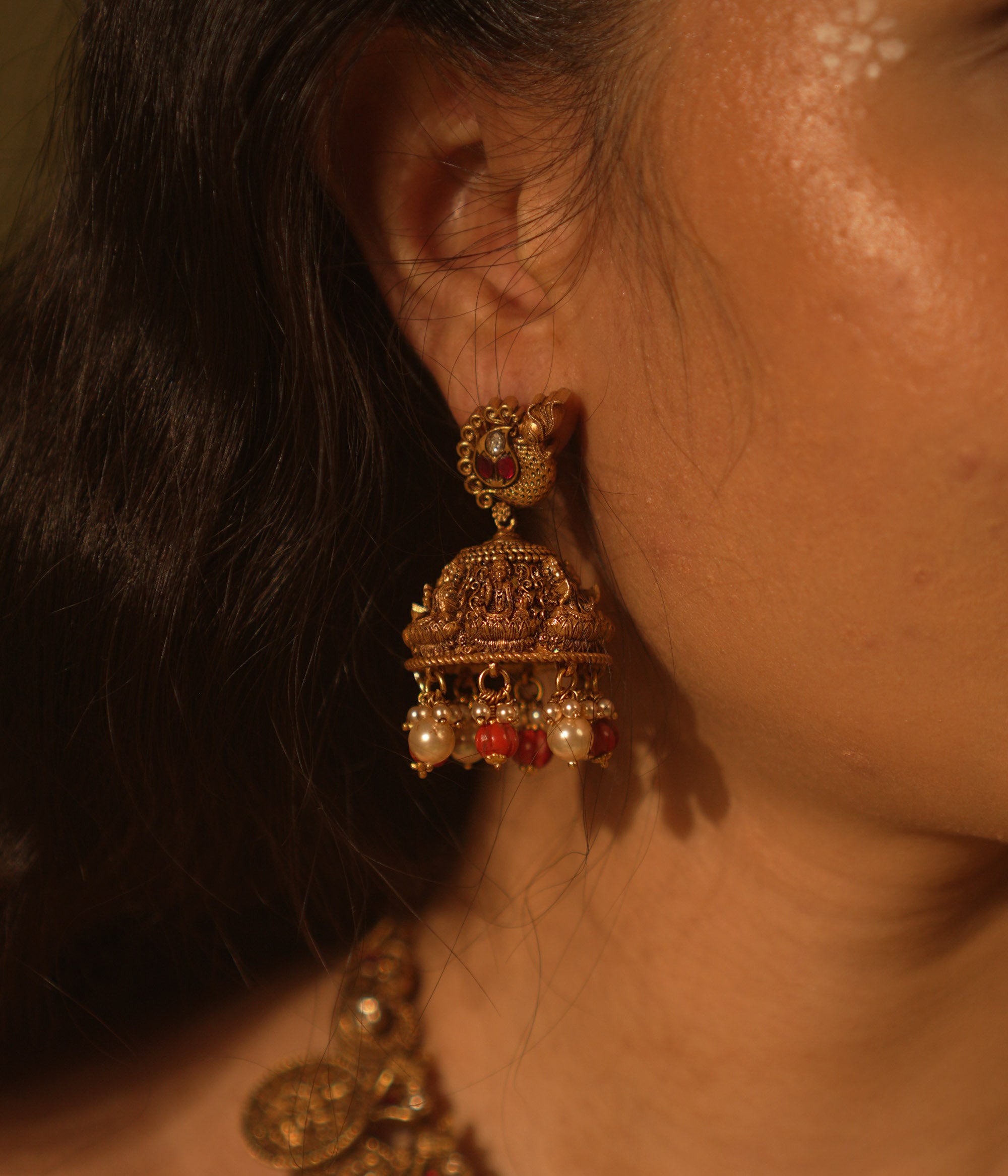 Temple collection Shyla Earrings featuring peacock motifs, Basra pearls, coral accents, and intricate Goddess Lakshmi-inspired jhumka design.