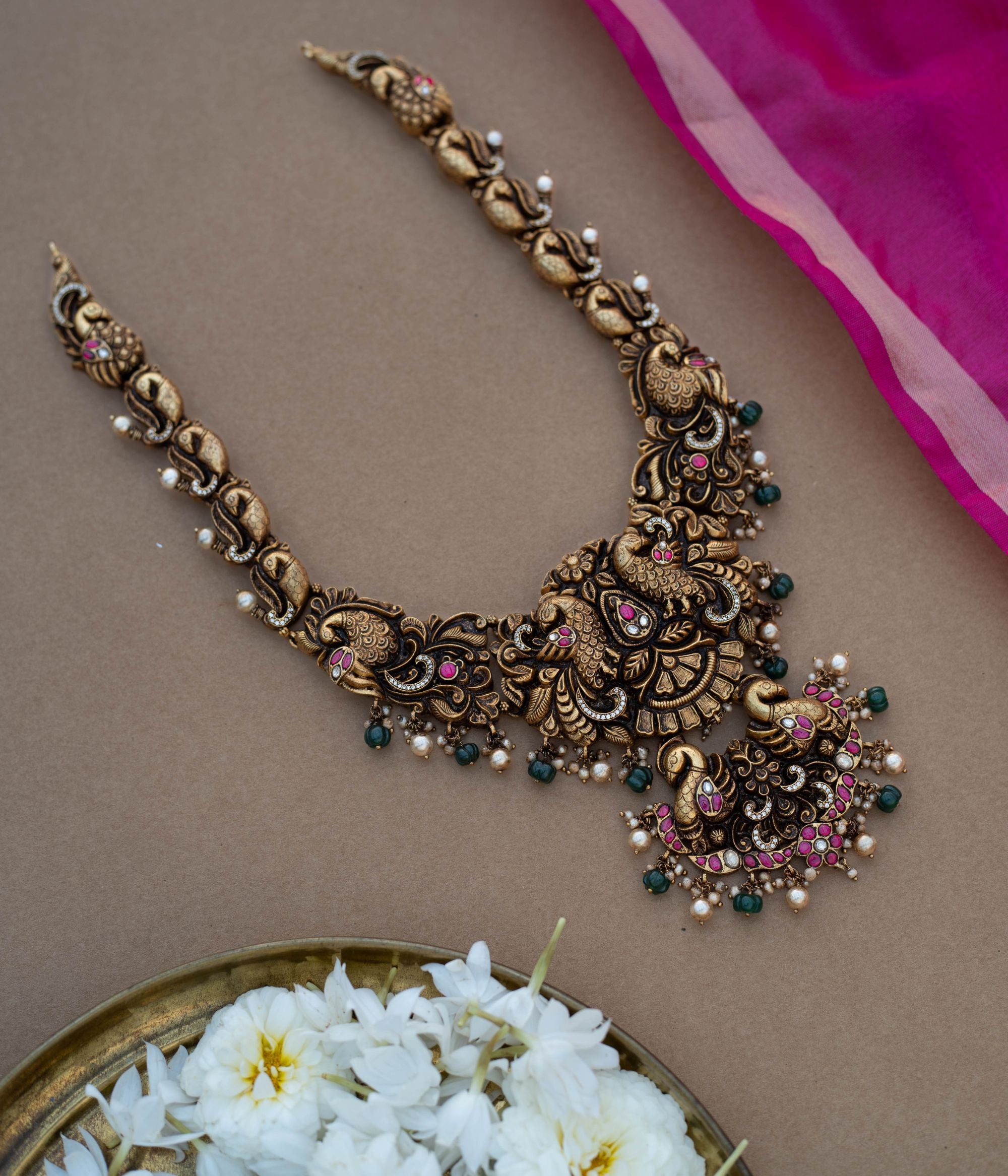 Traditional Rakni Necklace in 92.5 Sterling Silver and 22ct Gold Plated, featuring Kundan stones, green beads, and white pearls, with intricate peacock design and antique gold finish.