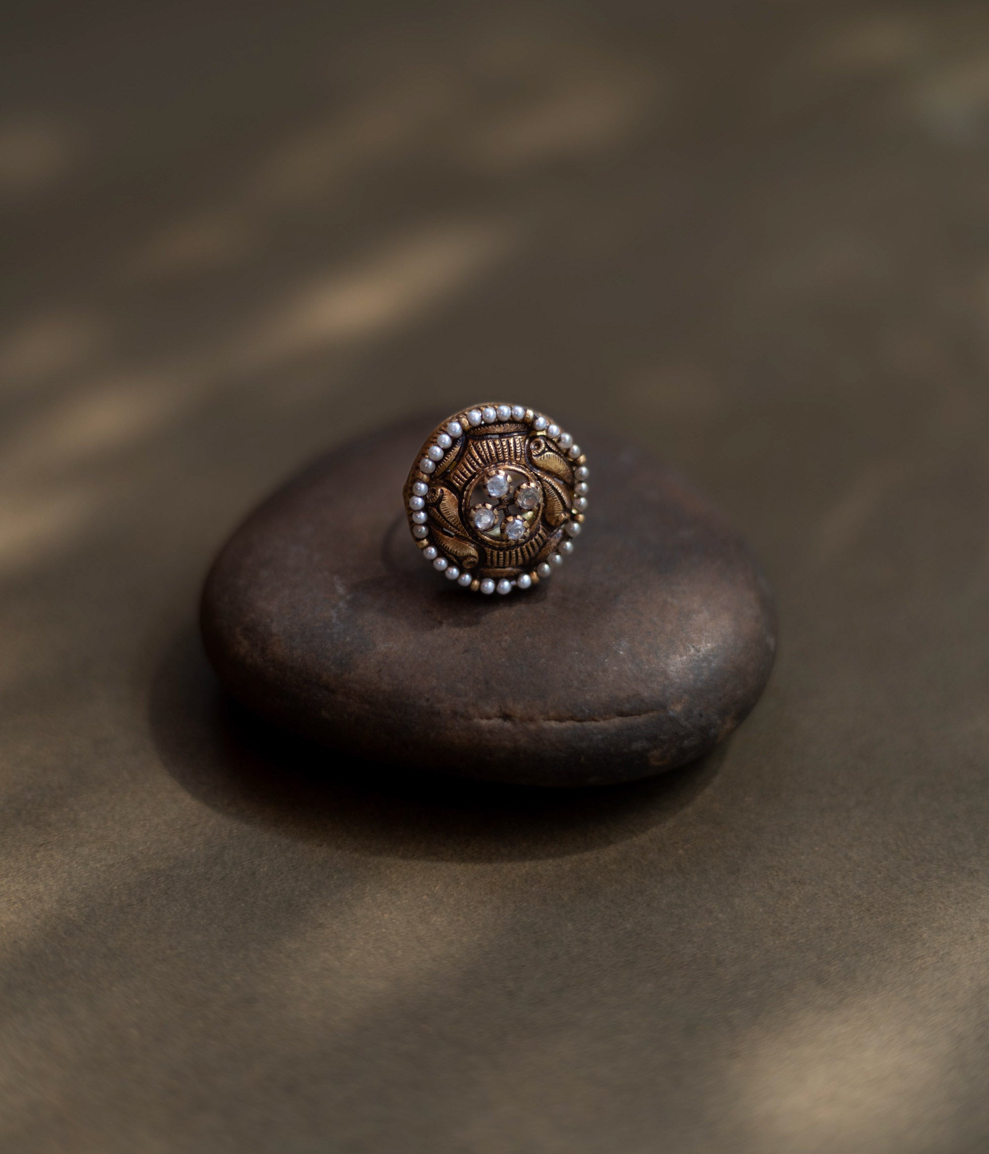 Heritage Glow Antique Ring: a mirror to ancient souls, encircled by golden carvings and a pearl halo. A tiny bird whispers tales of heritage on your finger.