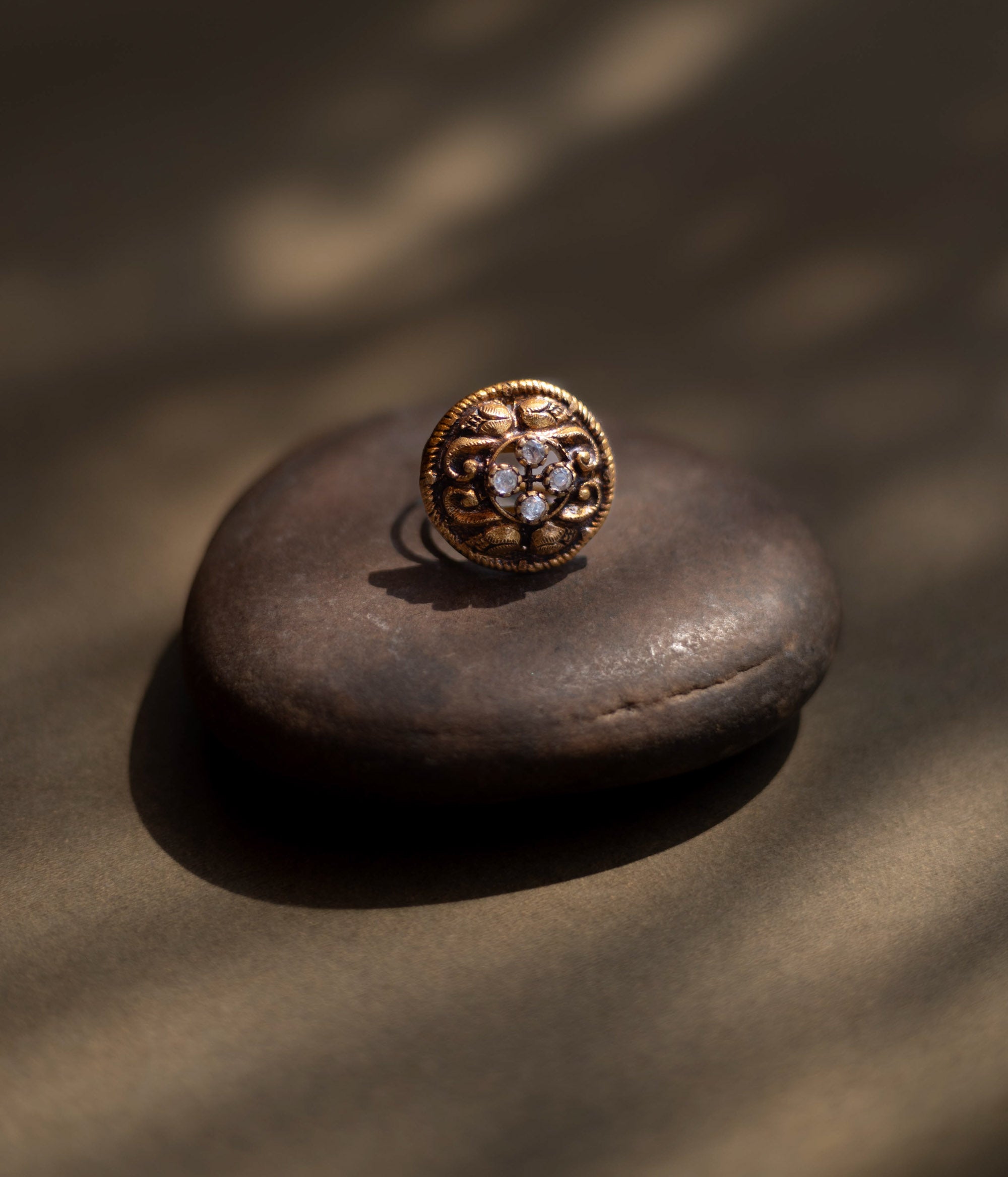 Antique gold-toned ring with ornate floral motif and radiant central mirror stones" is well-suited for the product description of the "Eternal Blossom Antique Ring."