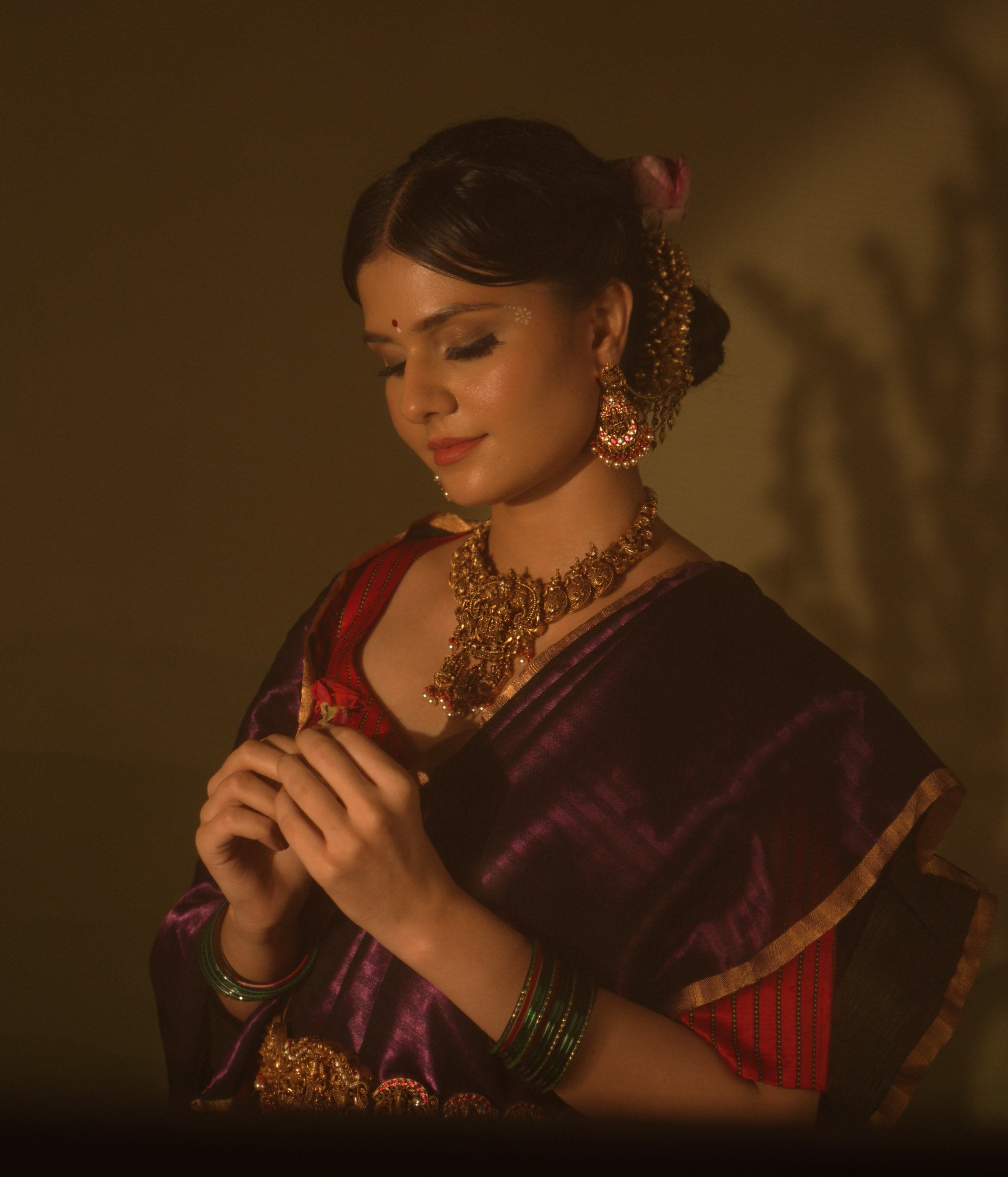 Simhika temple necklace with goddess motifs, lion guardians, red Kundan stones, and pearl detailing.