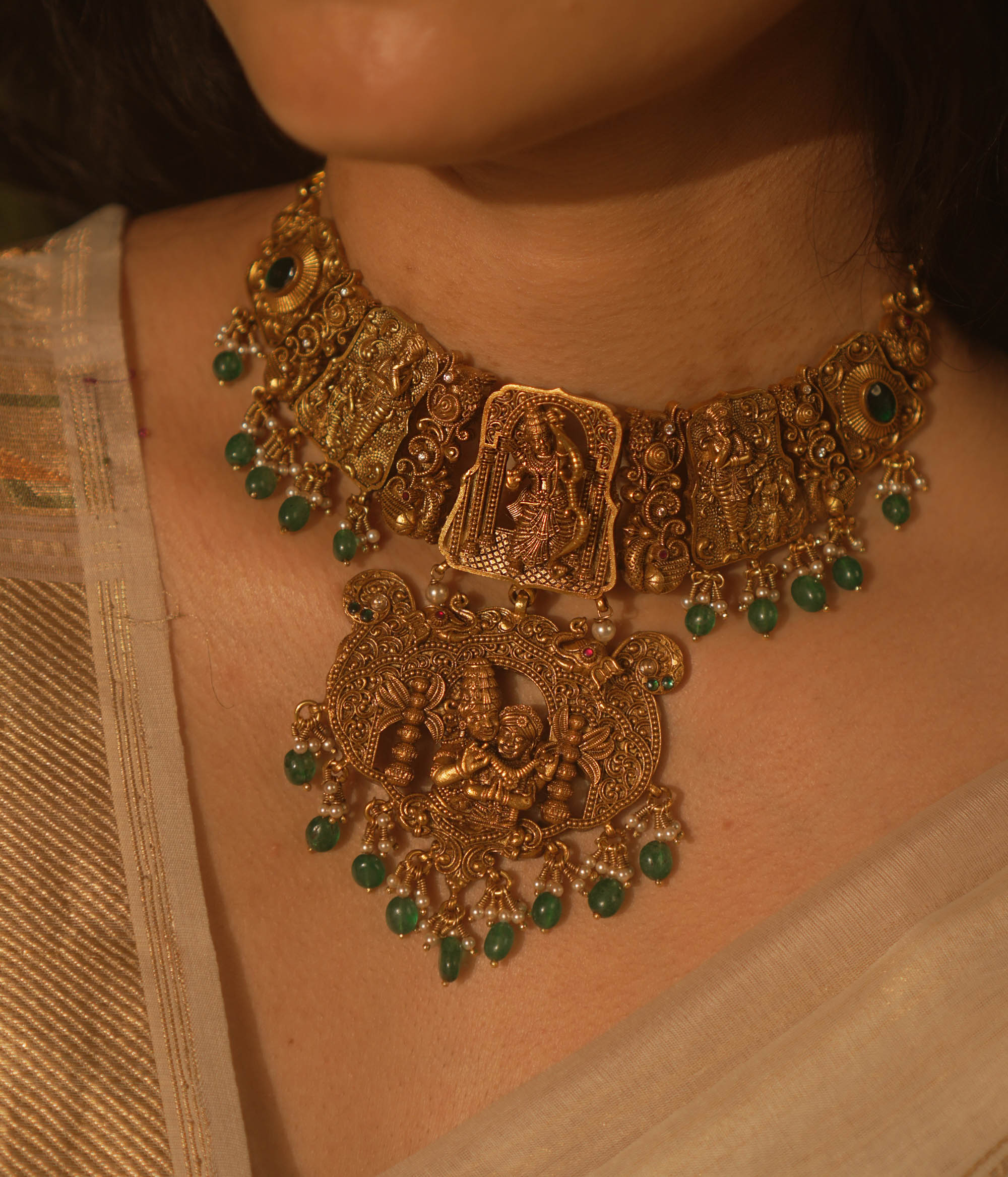 Temple collection Aadhavi Necklace inspired by Ramayana, adorned with green gemstones, Basra pearls, and intricate temple motifs.