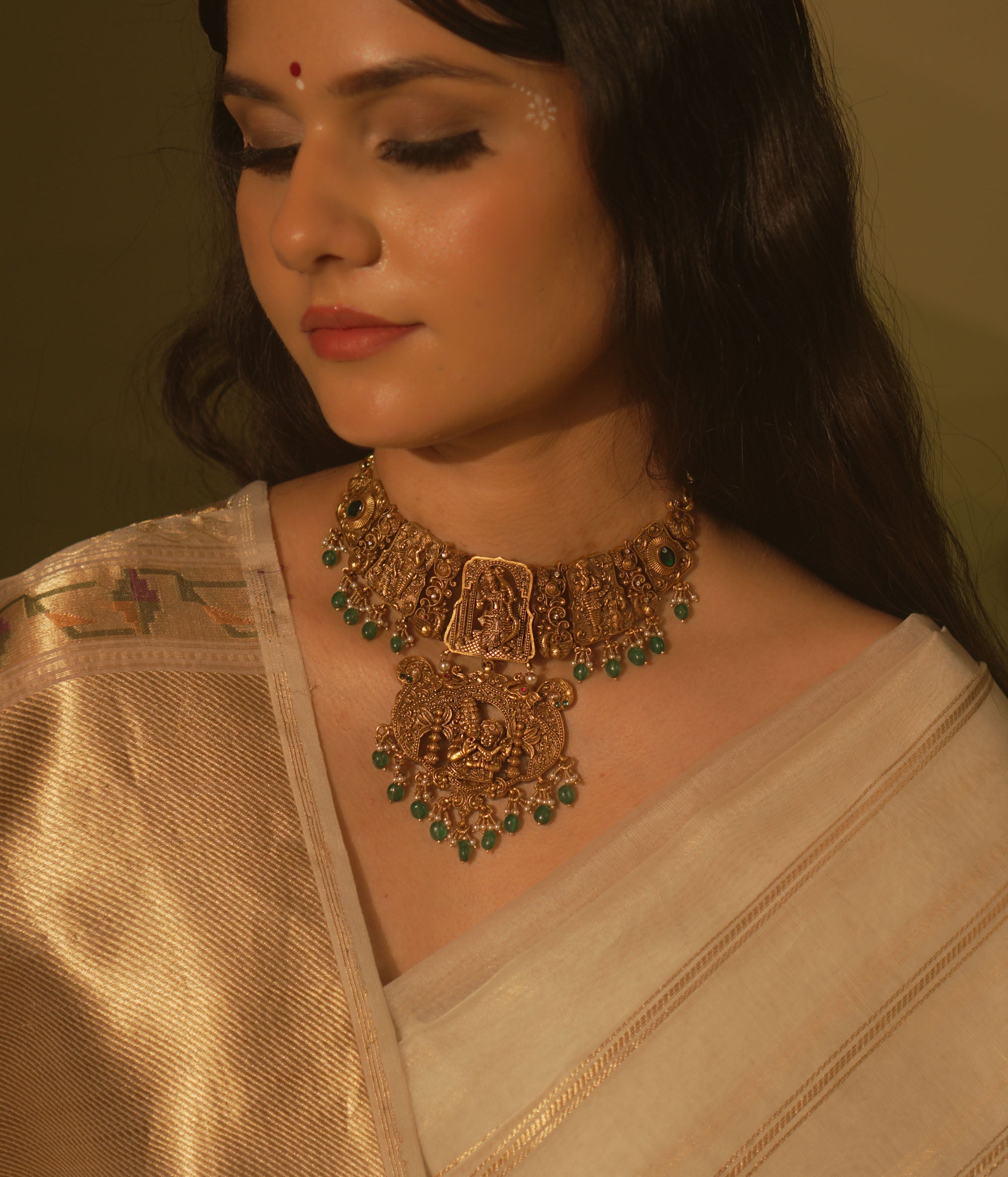 Temple collection Aadhavi Necklace inspired by Ramayana, adorned with green gemstones, Basra pearls, and intricate temple motifs.