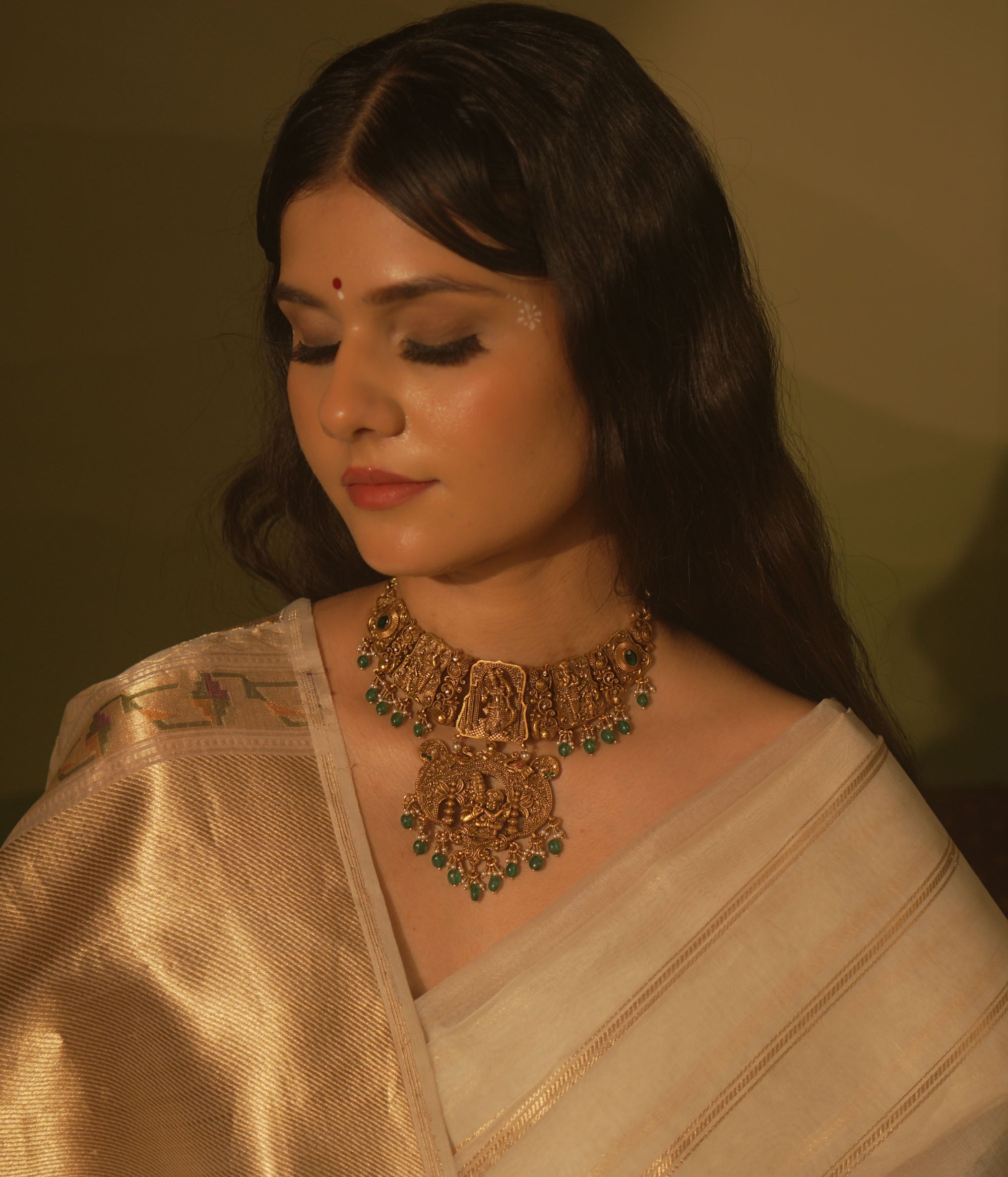 Temple collection Aadhavi Necklace inspired by Ramayana, adorned with green gemstones, Basra pearls, and intricate temple motifs.