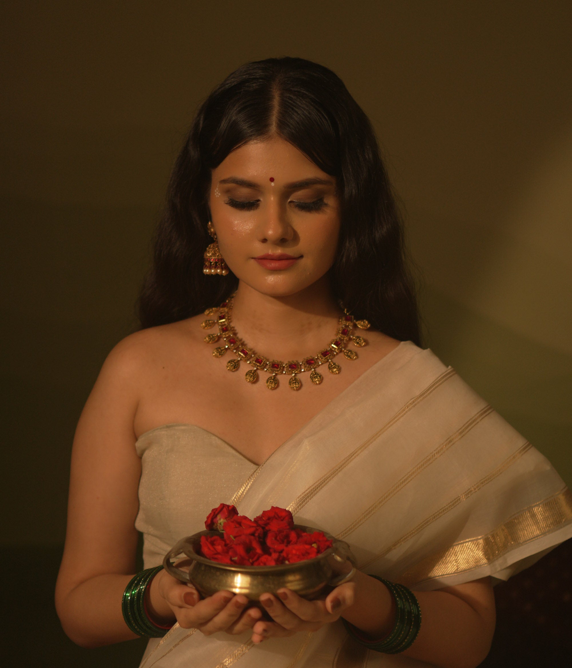 Temple-inspired necklace with red gemstones and Lakshmi motifs, blending divine elegance and traditional craftsmanship.