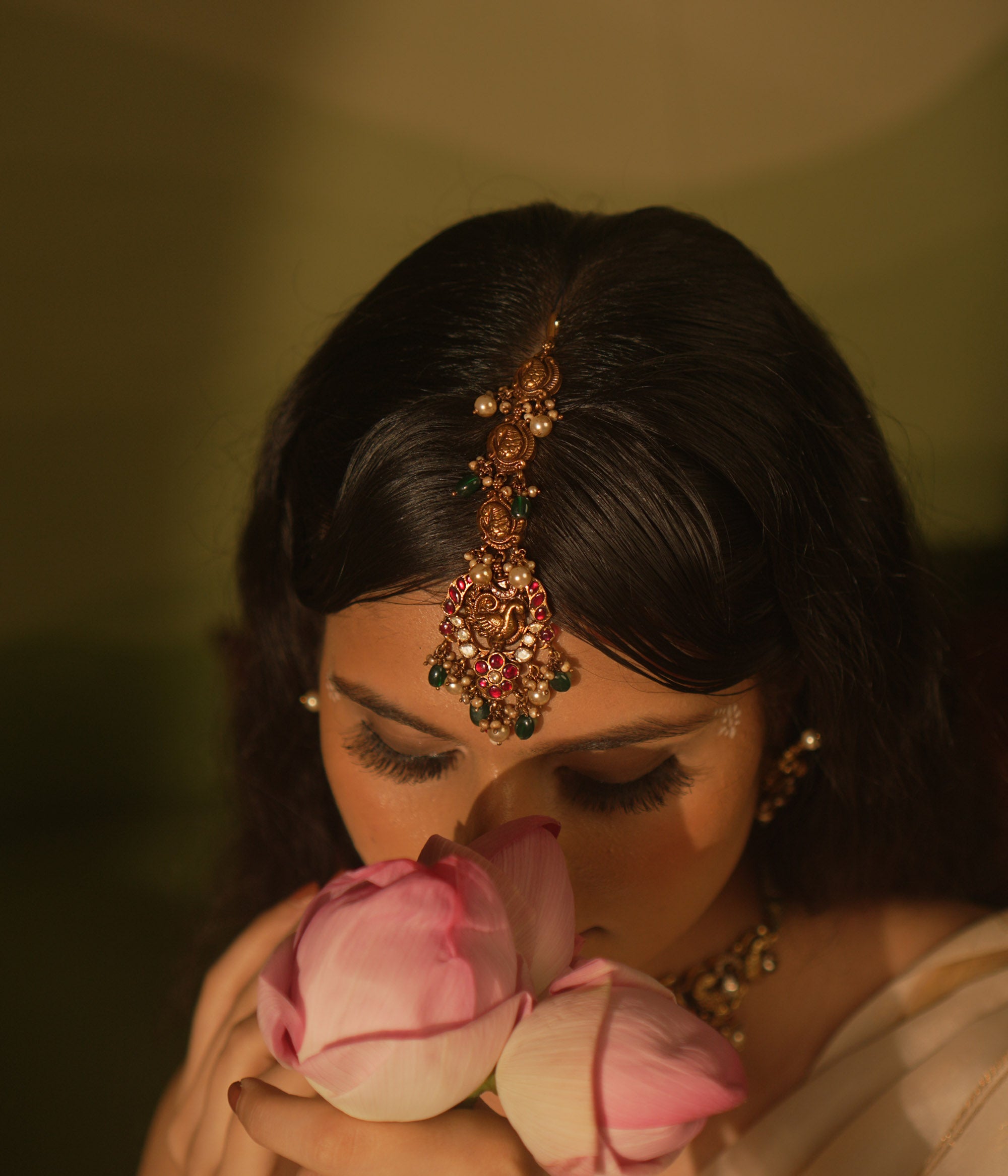 Temple collection maangtika featuring peacock and floral designs with Kundan stones, pearls, and emerald beads for traditional elegance.
