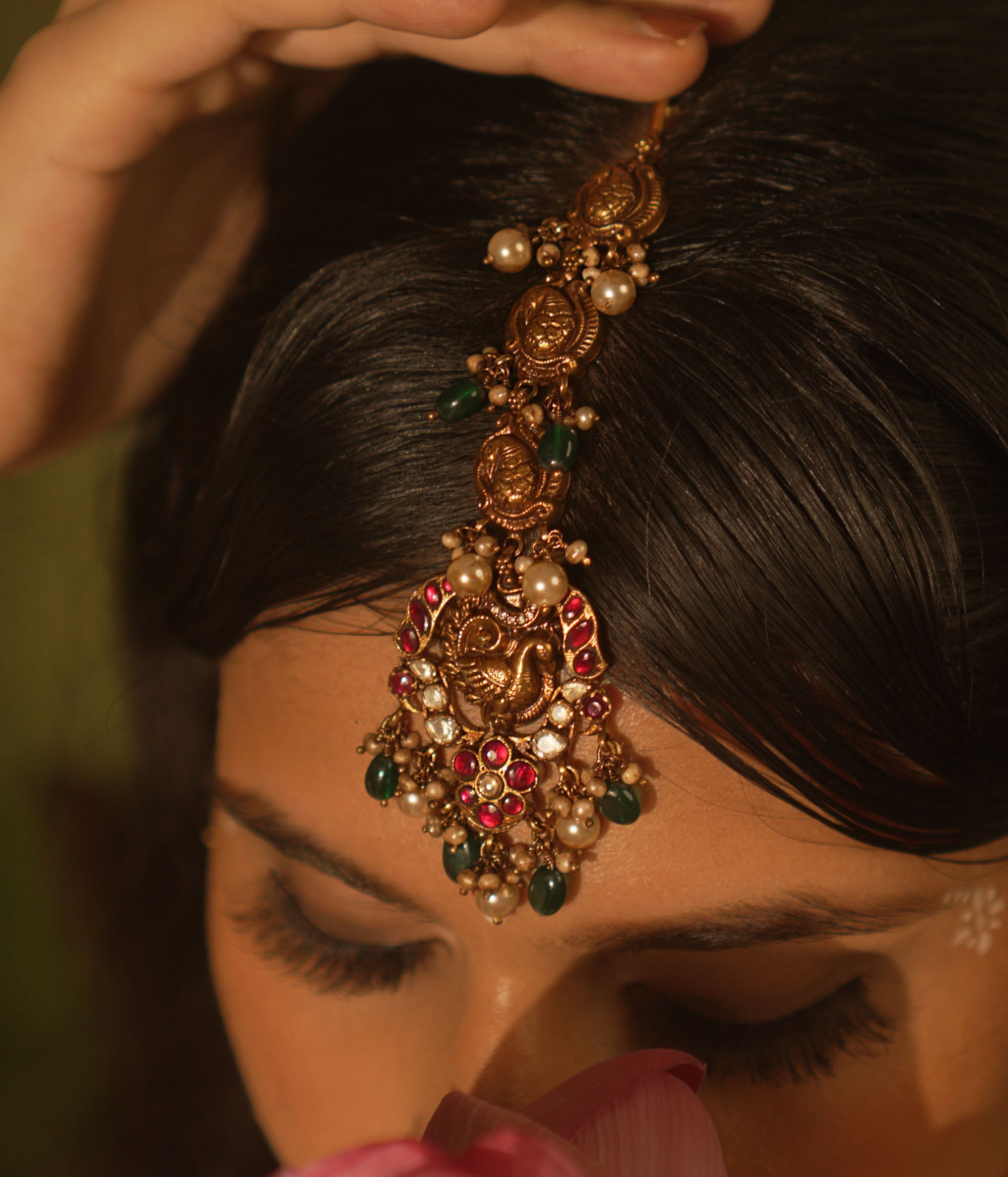 Temple collection maangtika featuring peacock and floral designs with Kundan stones, pearls, and emerald beads for traditional elegance.
