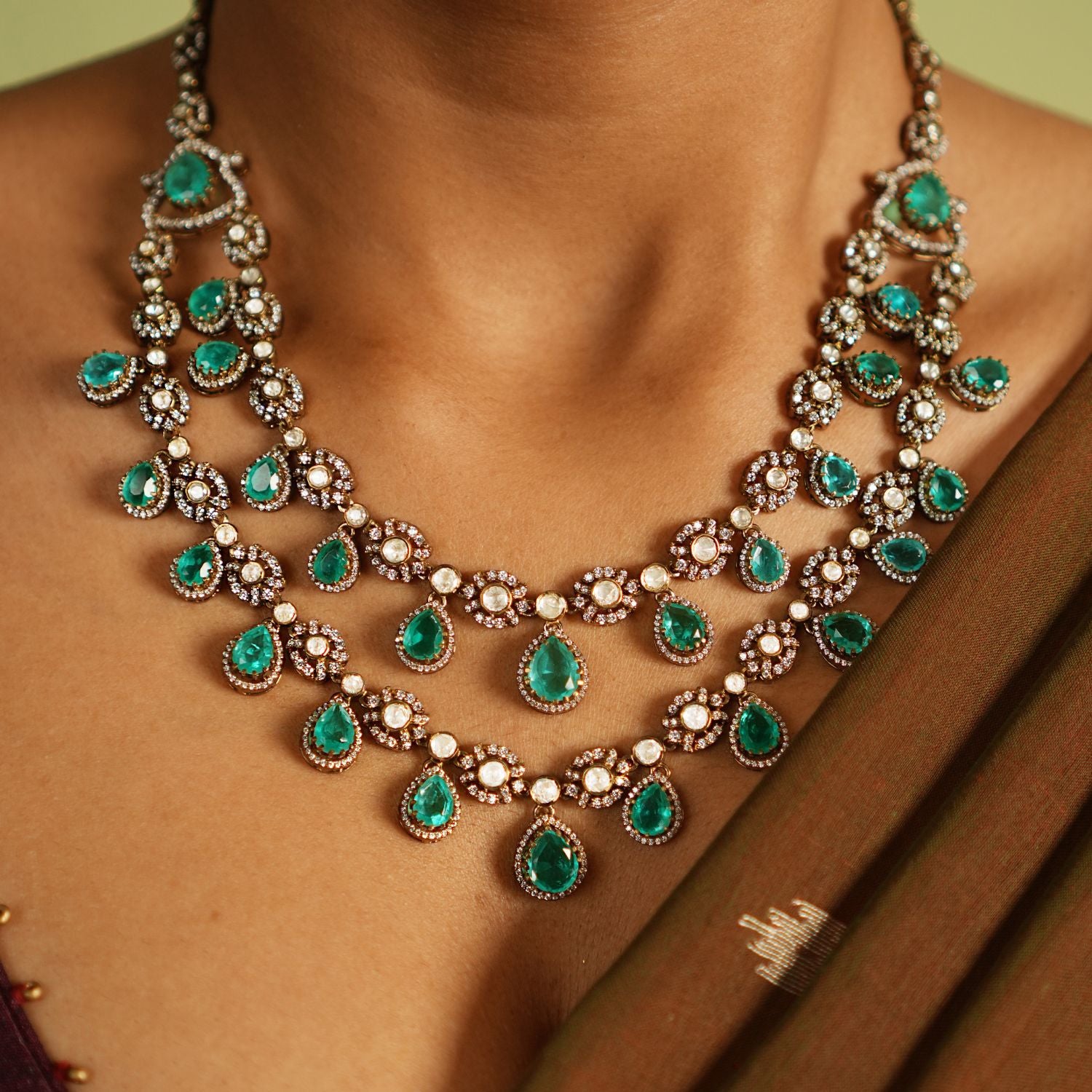 Exquisite two-layer gold-plated silver necklace adorned with moissanite Polki stones, CZ stones, and vibrant green gemstones, showcasing a timeless and sophisticated design perfect for any occasion.