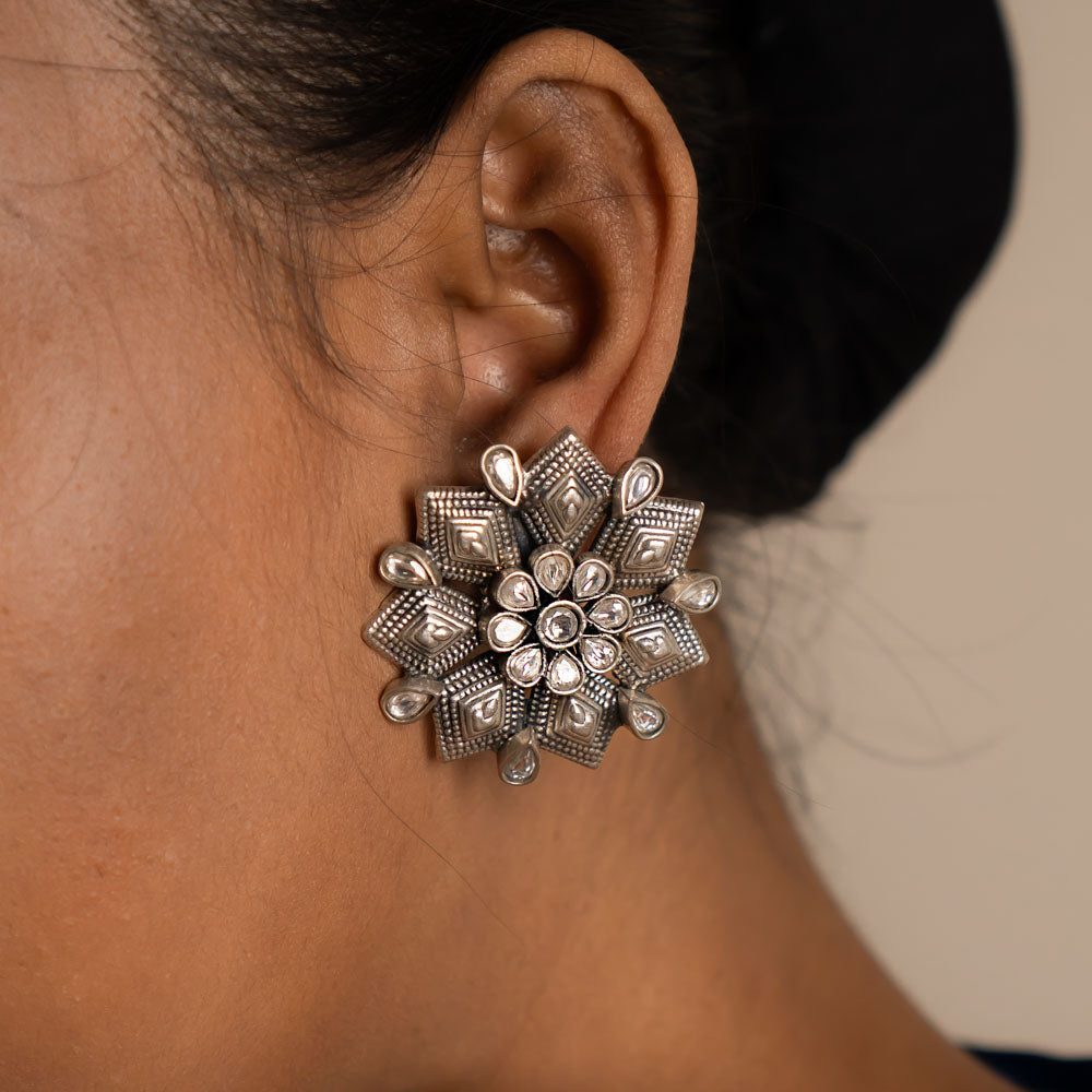 These earrings reinterpret the classic floral motif with a modern touch, featuring luminous white Kundan stones for a timeless yet minimal elegance.