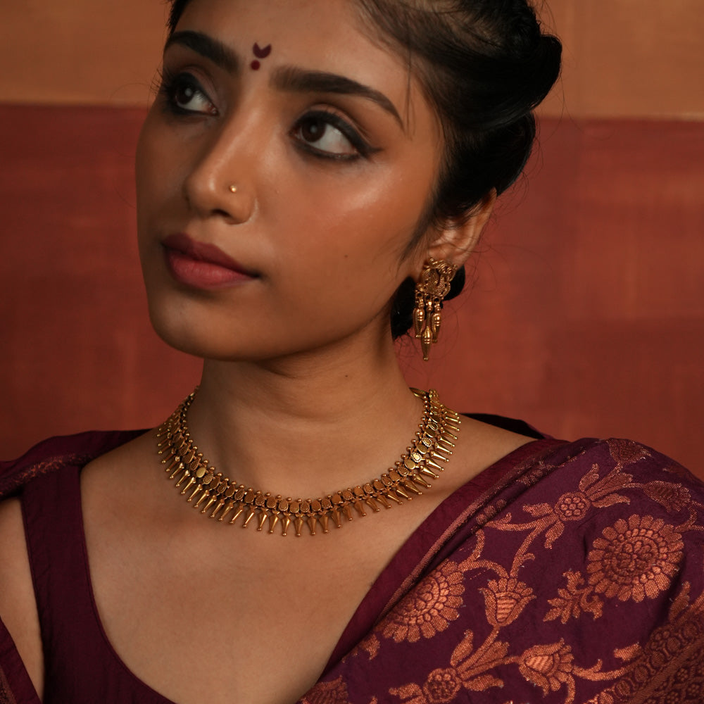 tribal Majesty Reborn. This gold-plated silver necklace, adorned with intricate designs and a striking spike-like pendant, is inspired by vintage Kolhapuri craftsmanship, offering a perfect fusion of timeless tradition and modern elegance.