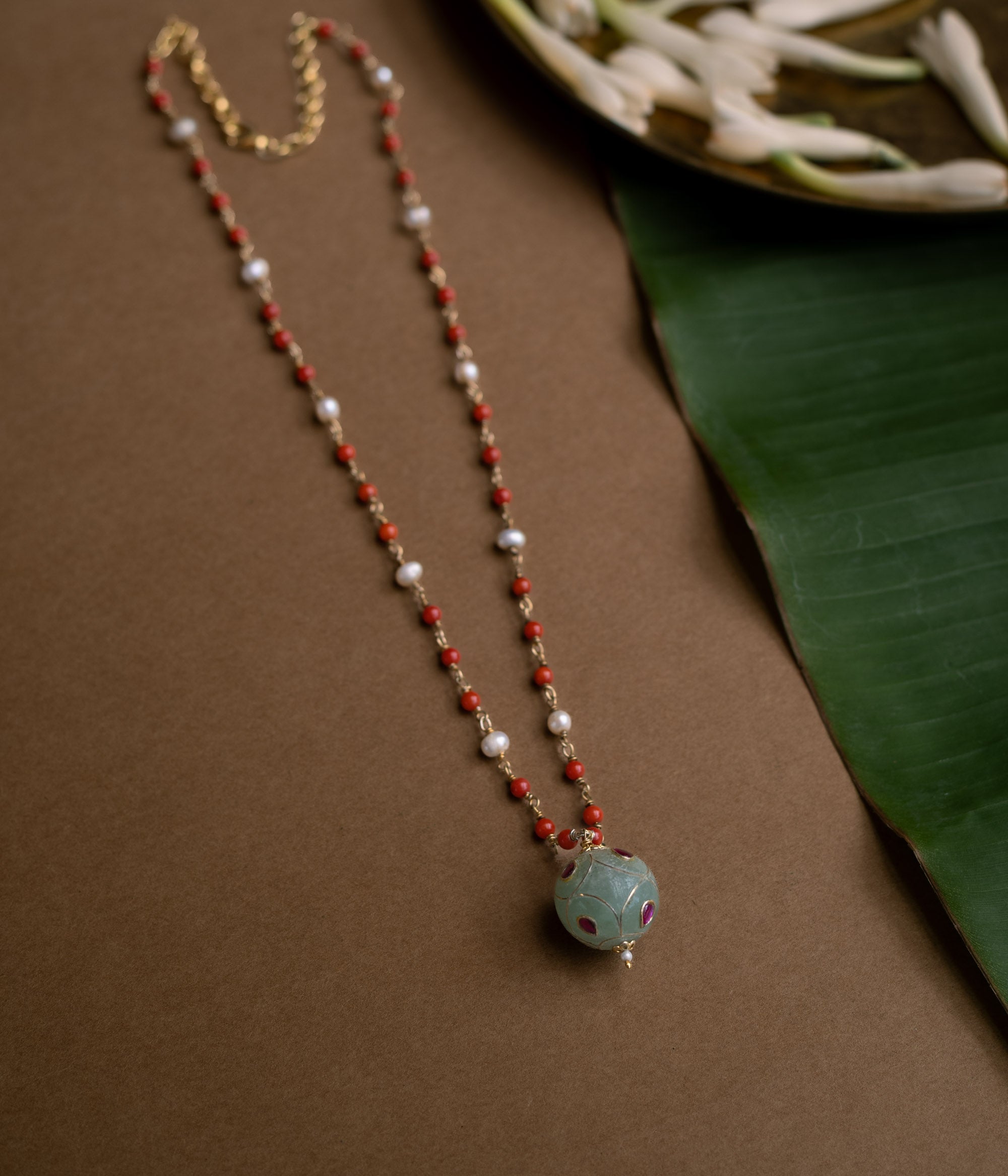 Hue collection chain with coral beads, pearls, and green stone sphere with red floral motifs.