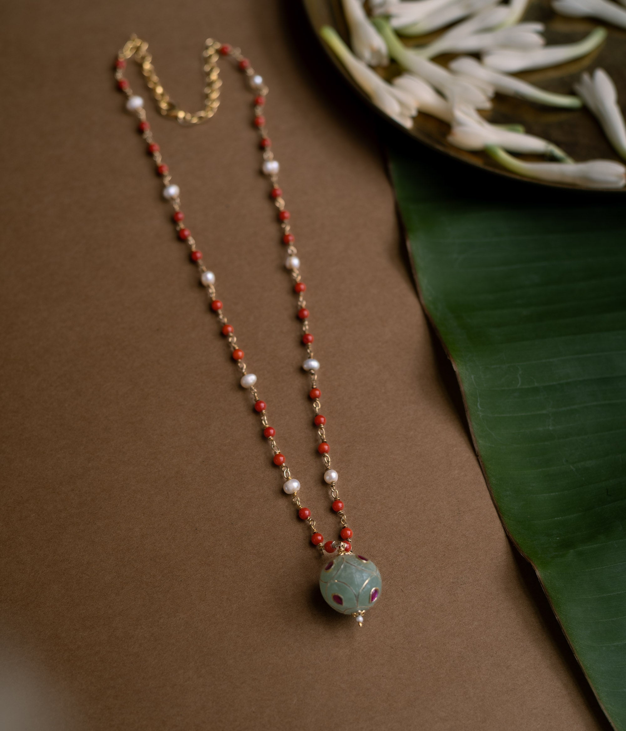 Hue collection chain with coral beads, pearls, and green stone sphere with red floral motifs.