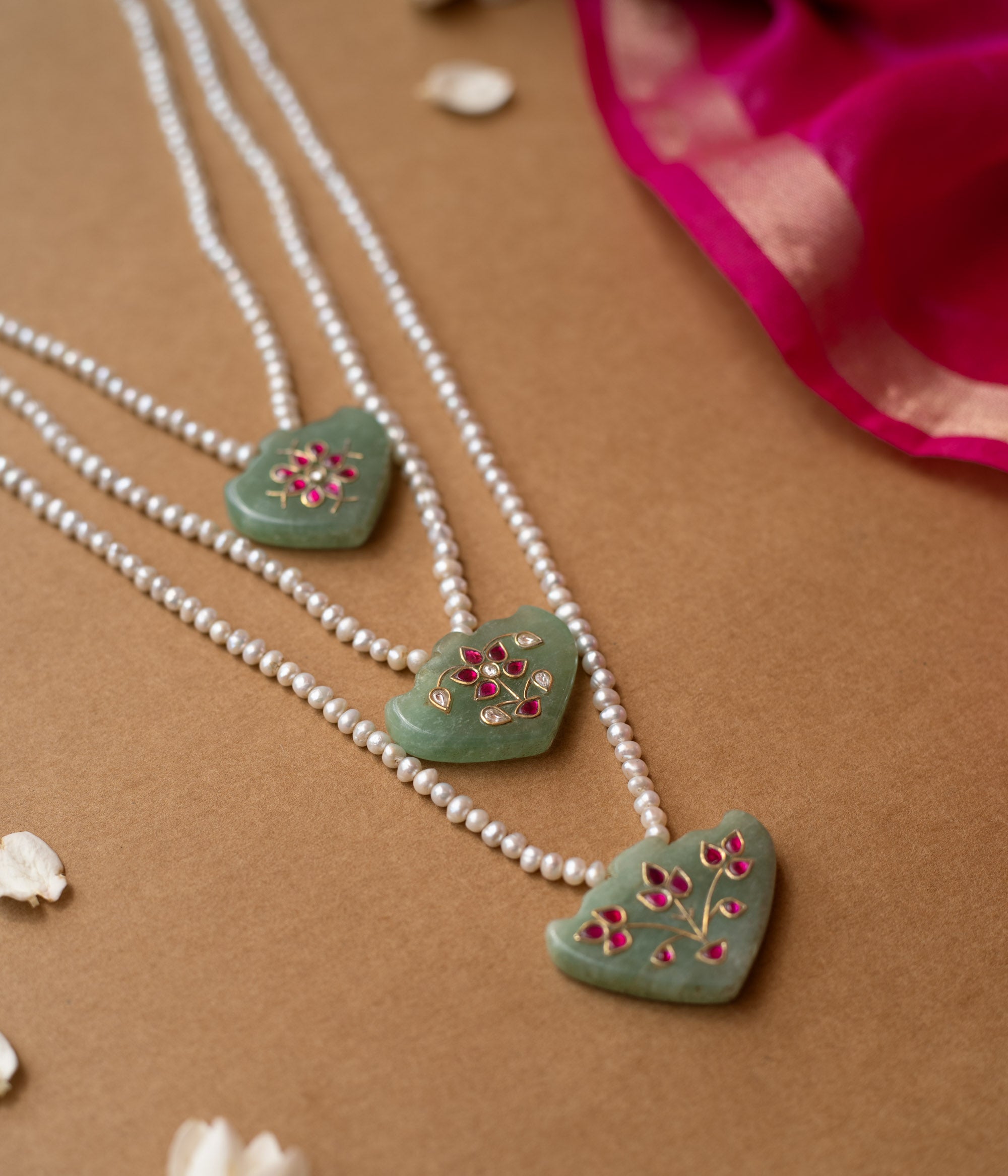 Hue collection pearl necklace with green stone pendants featuring pink floral motifs, elegant ethnic jewelry.