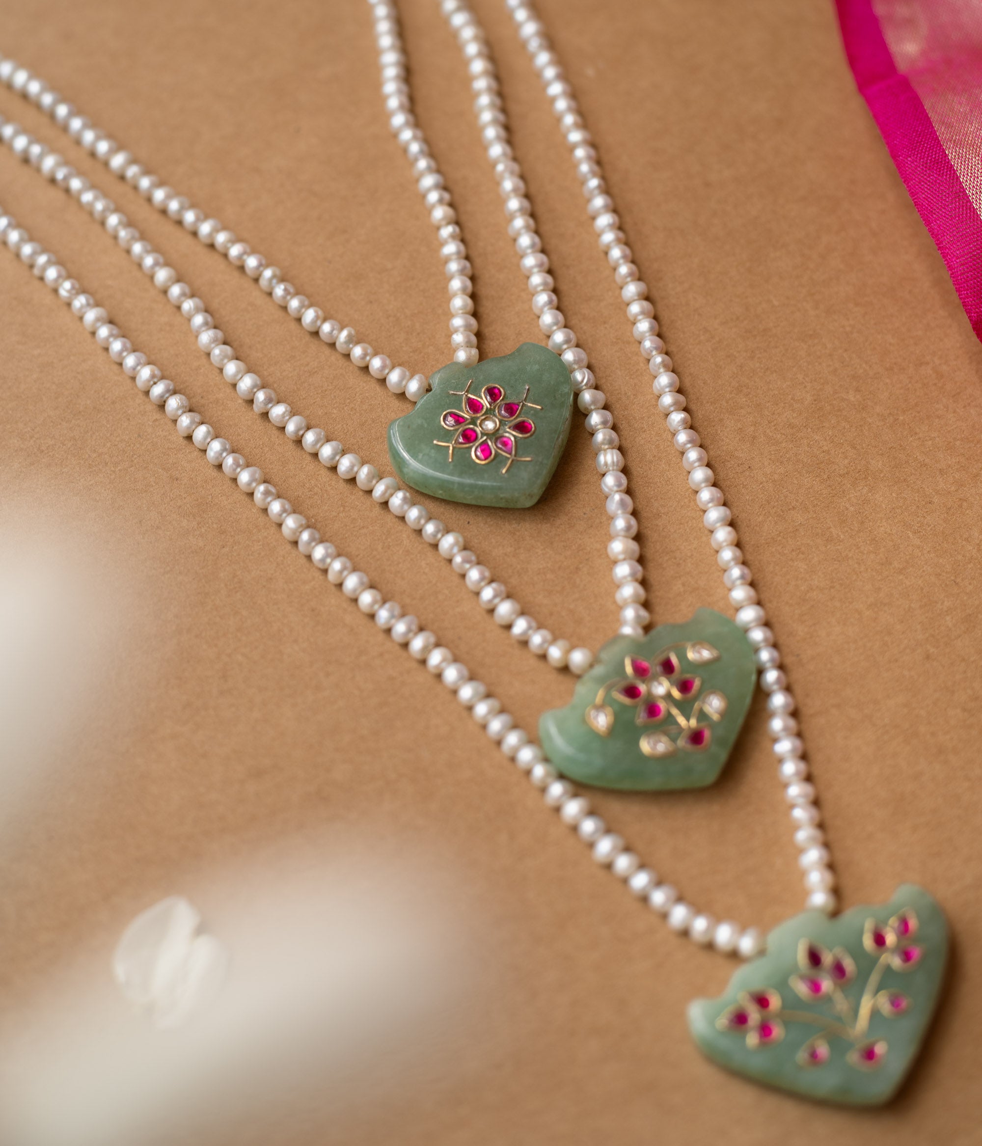 Hue collection pearl necklace with green stone pendants featuring pink floral motifs, elegant ethnic jewelry.