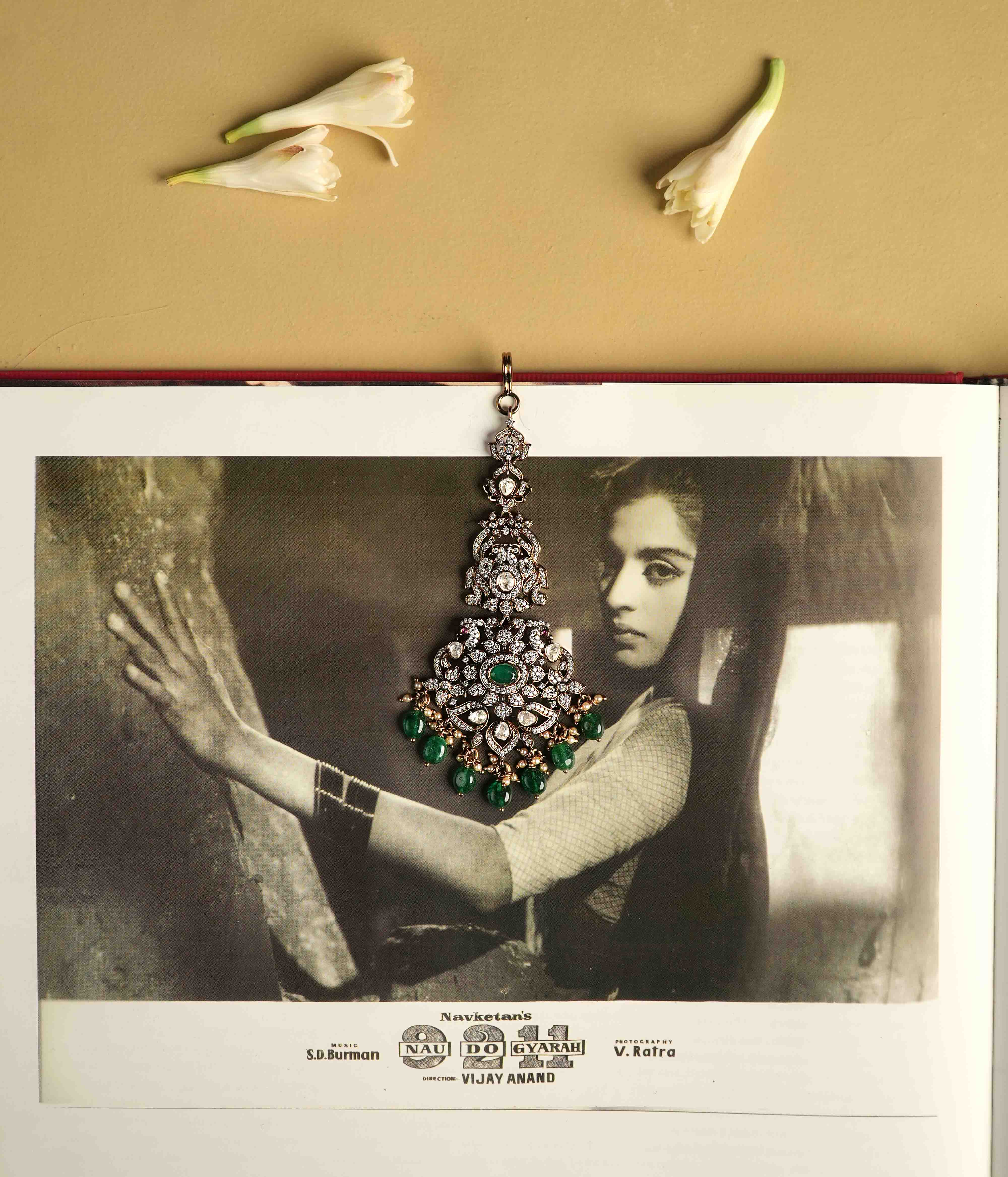This intricately crafted Maangtika, handmade from 92.5 sterling silver with 14ct dark antique gold plating, features polki stones, CZ stones, green gemstones, green beads, and pearls.  The design shines with polki and moissanite brilliance, with cultured emerald dangles adding a touch of majestic elegance, evoking the opulence of a Victorian era.