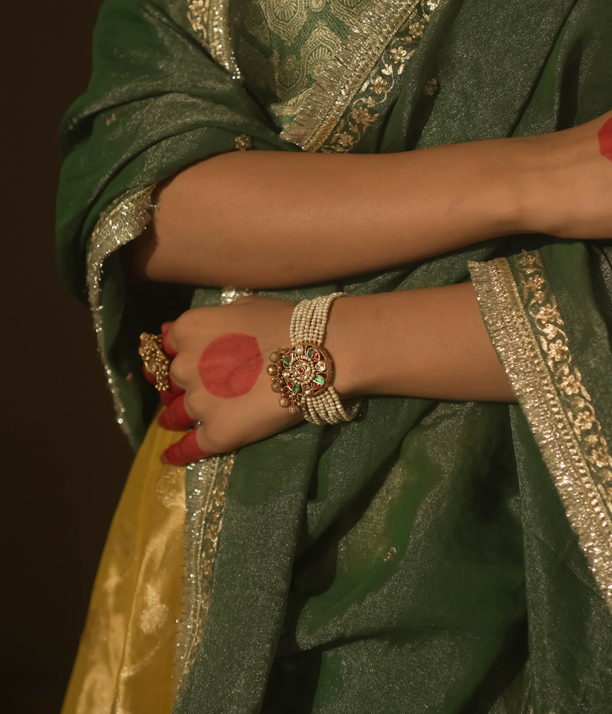 Bracelet with beaded pearls and a gold centerpiece studded with red and green Kundan.