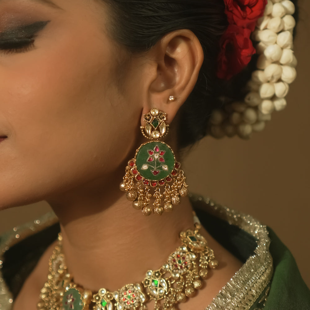 Gold-plated silver earrings with green enamel, red and clear Kundan, and tiny gold bells.