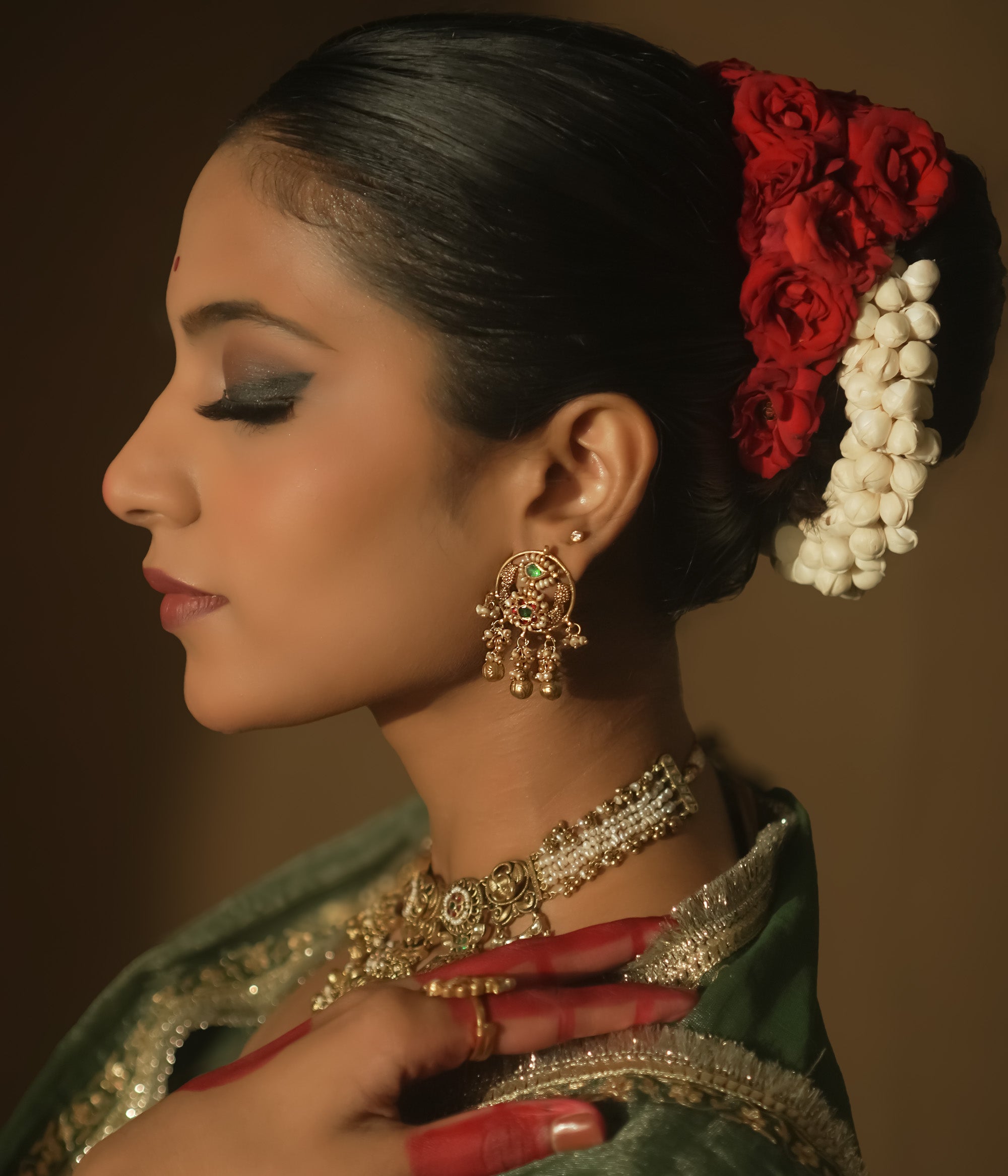 Gold Baali earrings with green and red Kundan gems and tiny bells.