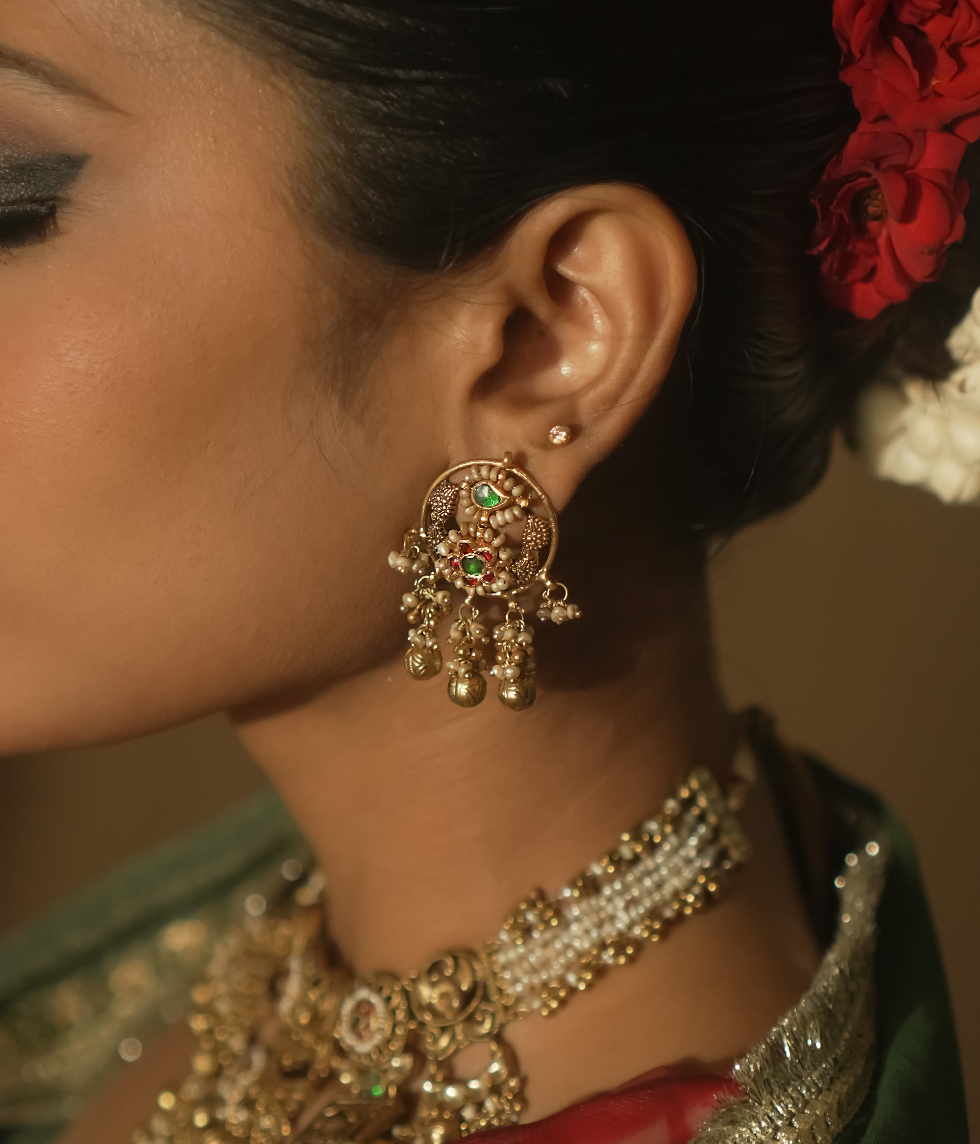 Gold Baali earrings with green and red Kundan gems and tiny bells.