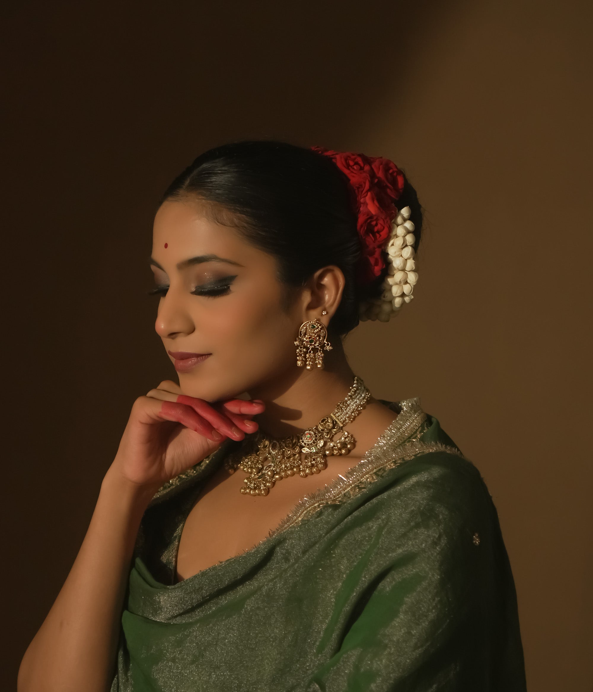 Gold Baali earrings with green and red Kundan gems and tiny bells.