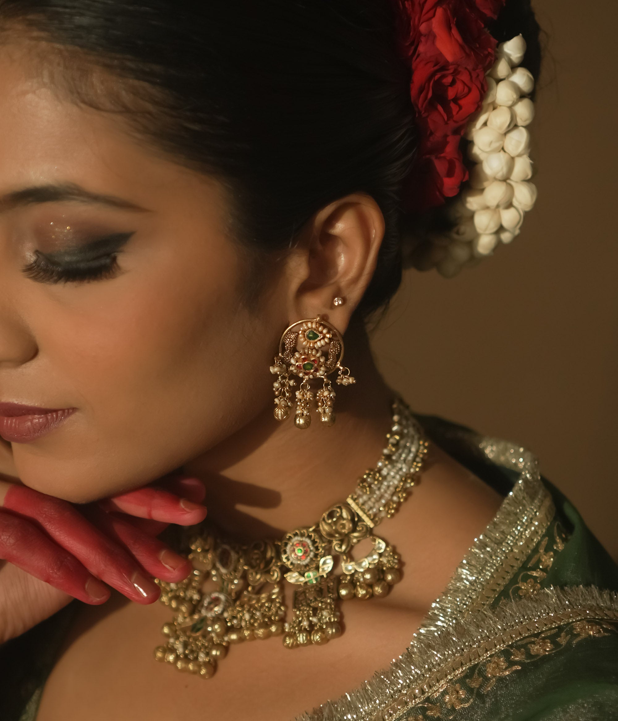 Gold Baali earrings with green and red Kundan gems and tiny bells.