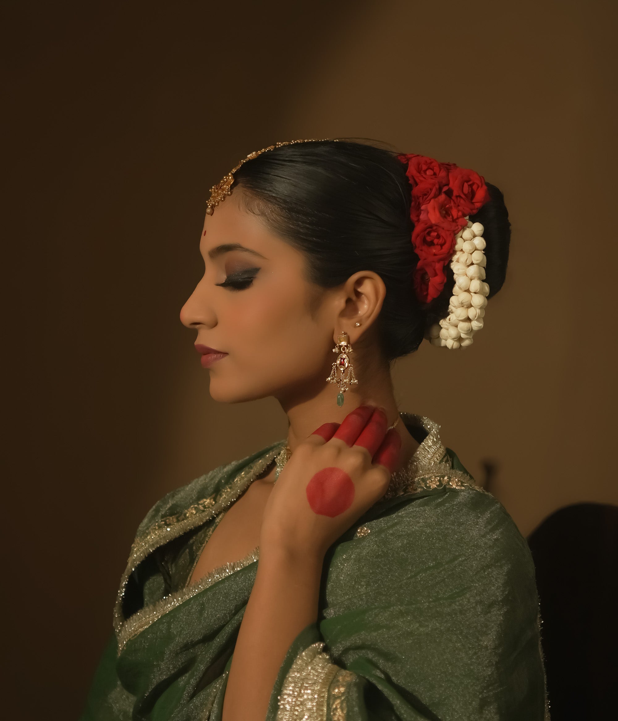 Dangling earrings with clear and red Kundan stones and teardrop emeralds.
