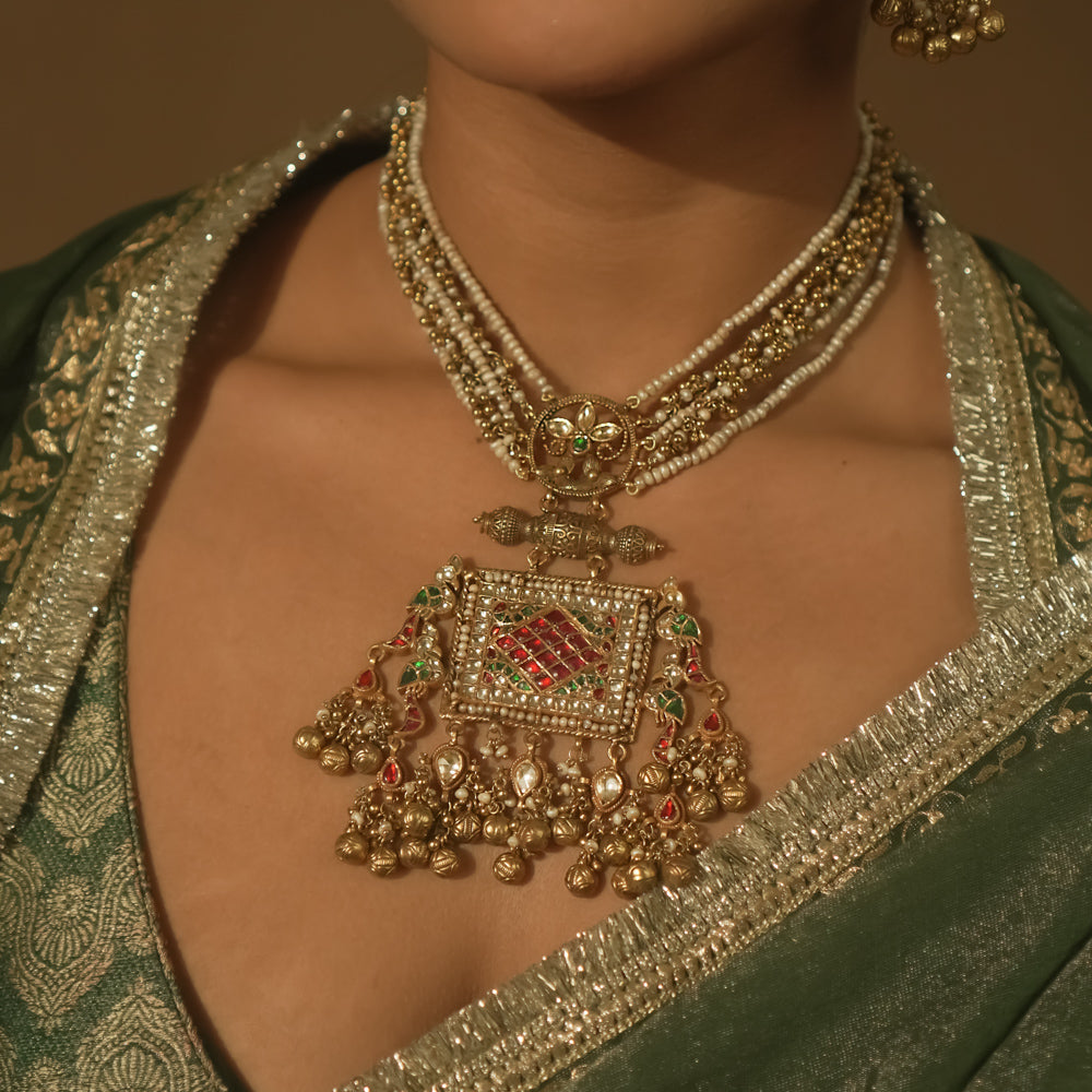 Necklace with pearls, gold-plated silver, and a pendant with red and green Kundan stones.