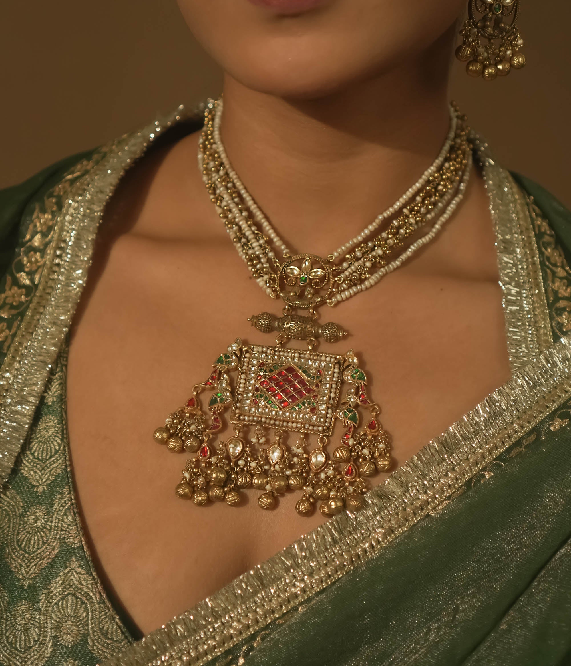 Necklace with pearls, gold-plated silver, and a pendant with red and green Kundan stones.