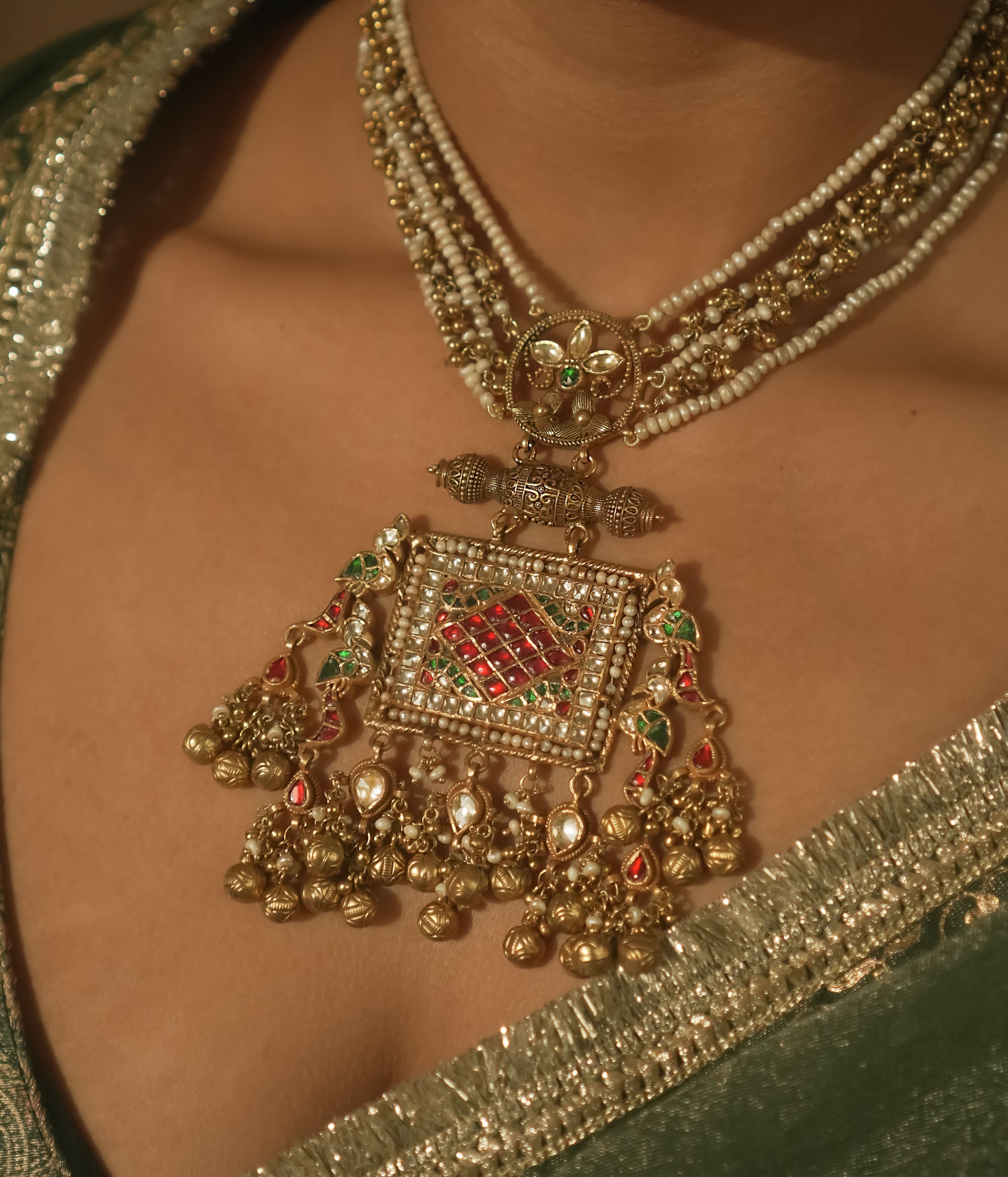 Necklace with pearls, gold-plated silver, and a pendant with red and green Kundan stones.